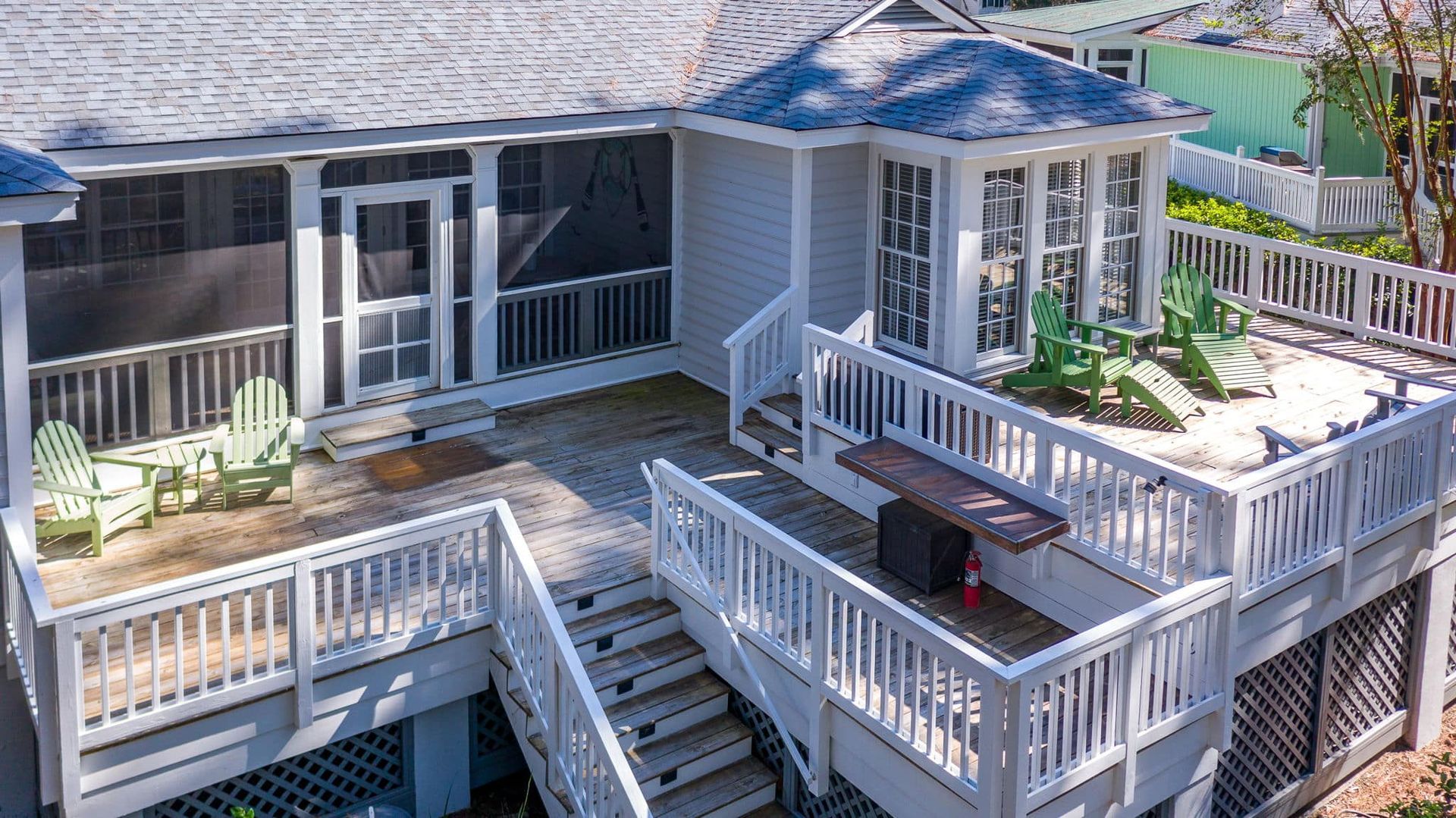 An aerial view of a house with a large deck and stairs leading up to it.