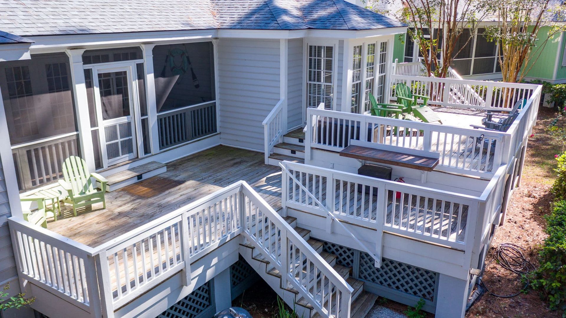 An aerial view of a house with a screened in porch and stairs leading to it.