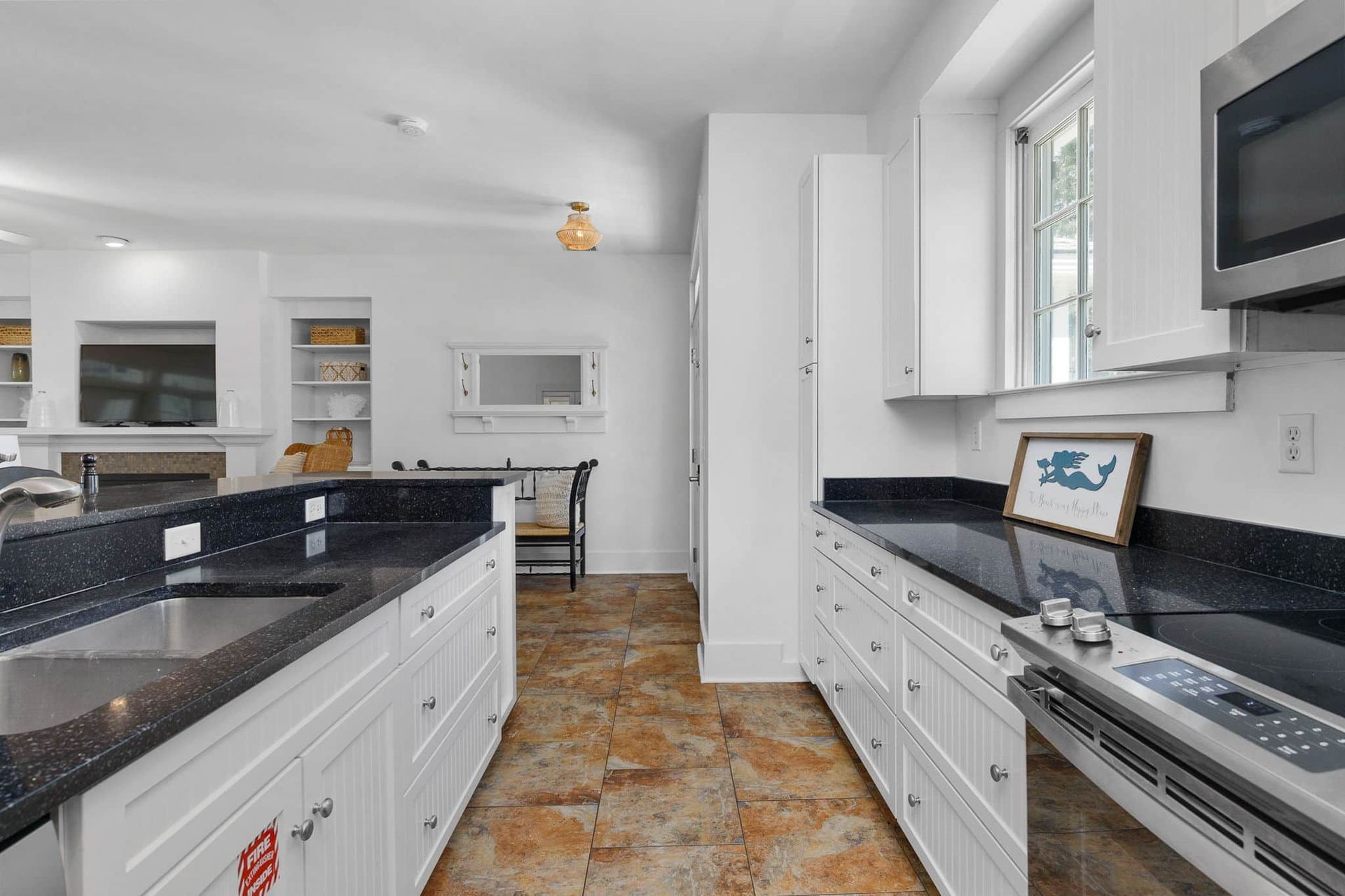 A kitchen with white cabinets and black counter tops