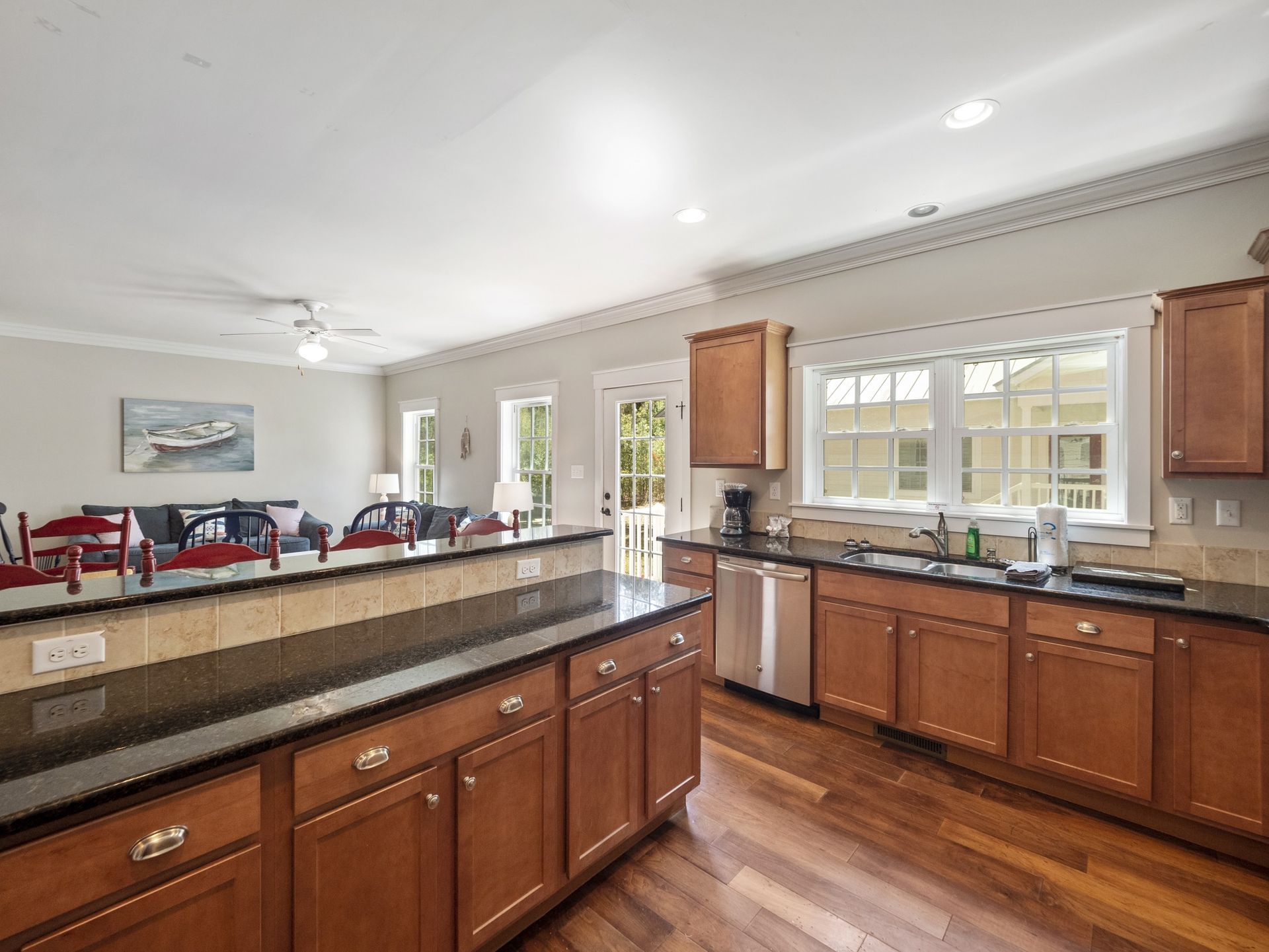 A kitchen with wooden cabinets , granite counter tops , and stainless steel appliances.