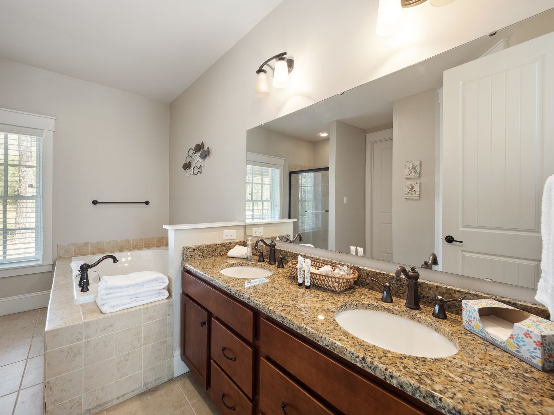A bathroom with two sinks and a large mirror.