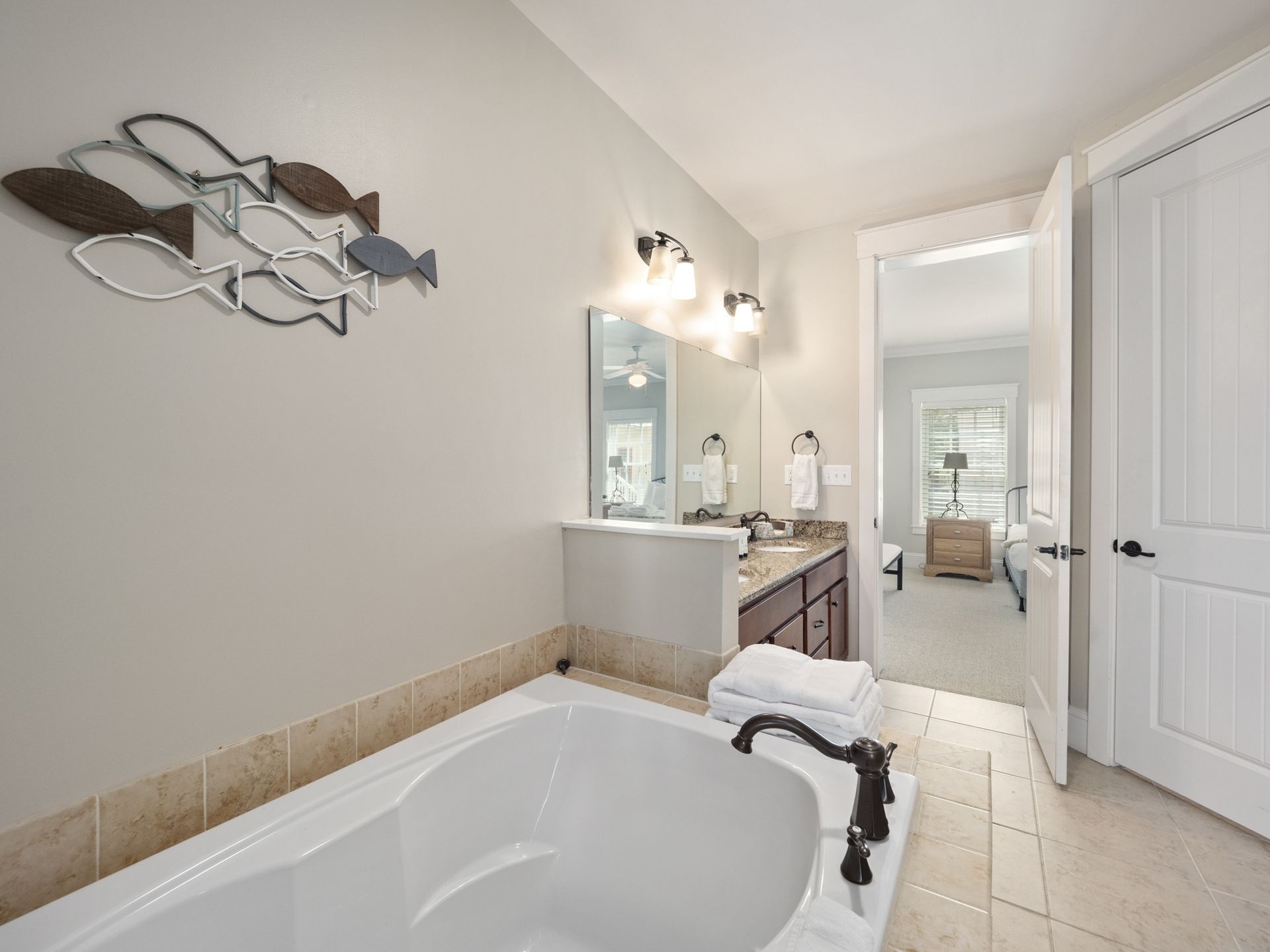 A bathroom with a bathtub , sink and mirror.