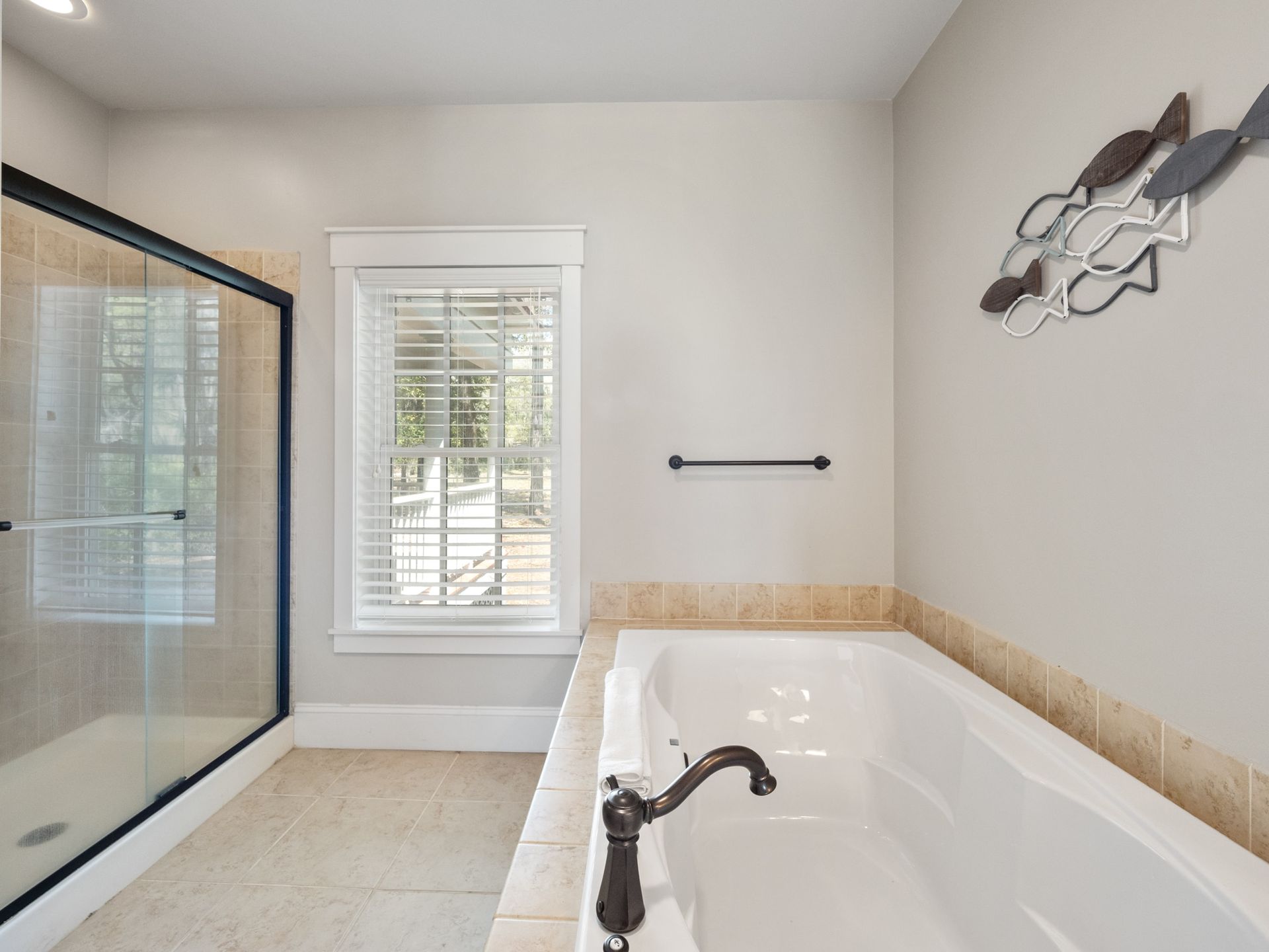 A bathroom with a tub , shower and window.