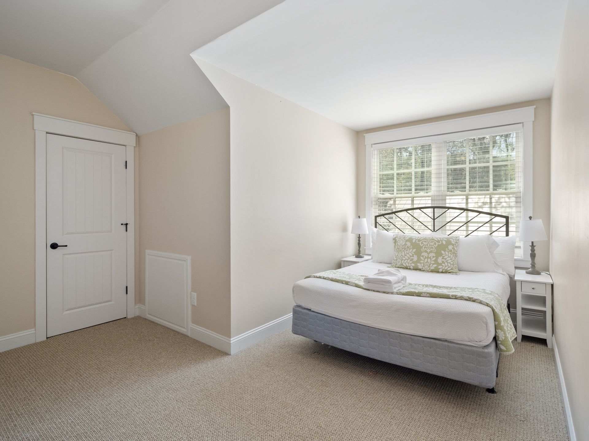 A bedroom with a large bed and a window.