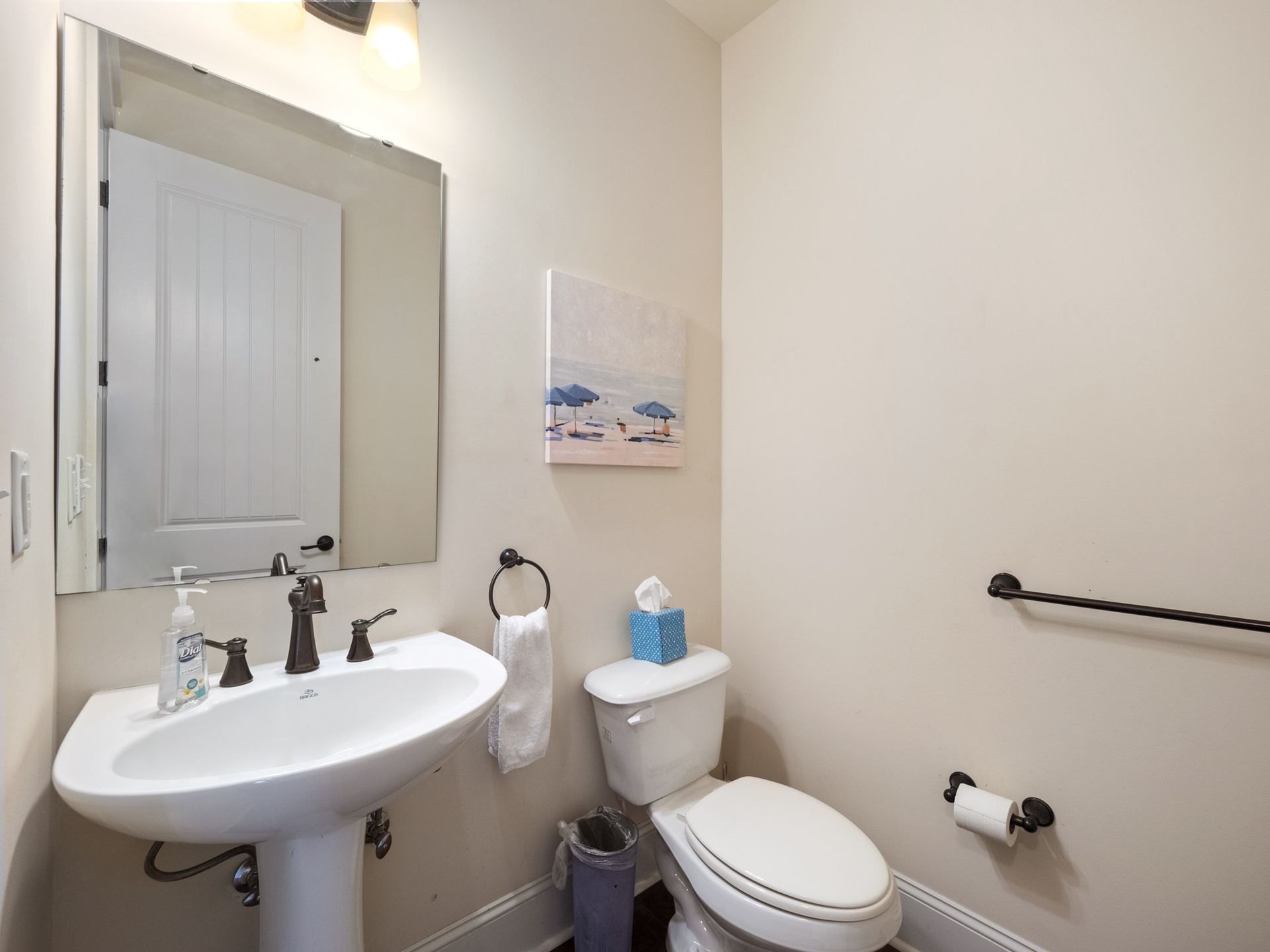 A bathroom with a sink , toilet and mirror.