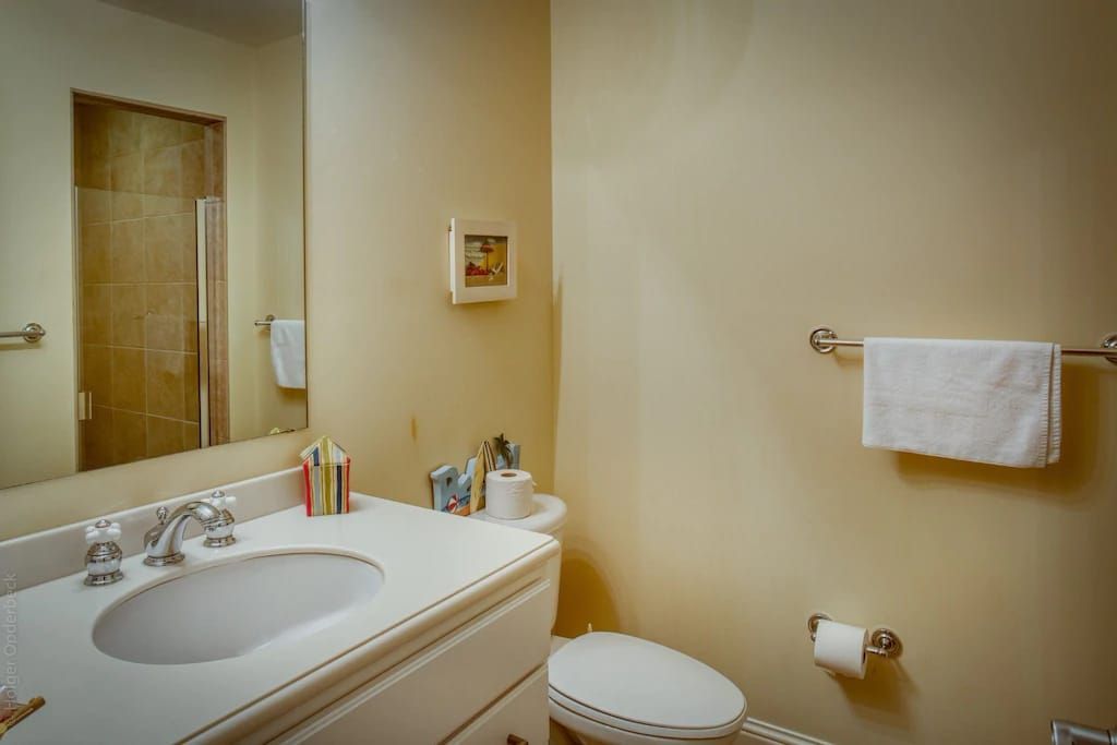 A bathroom with a sink , toilet and mirror.
