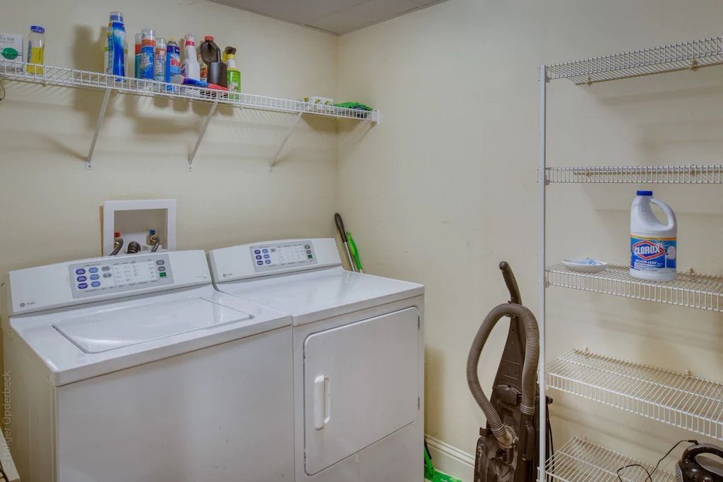 A laundry room with a washer and dryer and a vacuum cleaner.