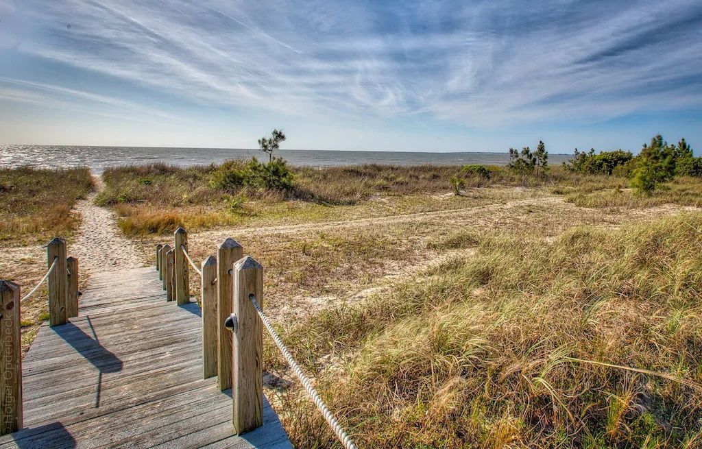 A wooden walkway leading to the beach on a sunny day.