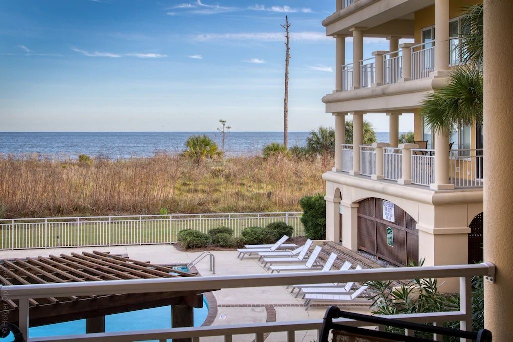A view of the ocean from a balcony of a large house.