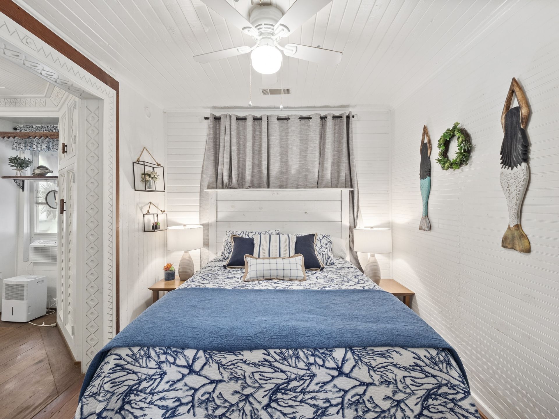 A bedroom with a bed and a ceiling fan