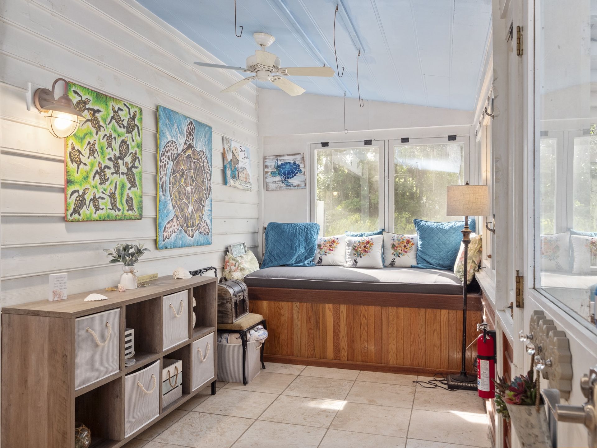 A living room with a wooden bench and a ceiling fan.