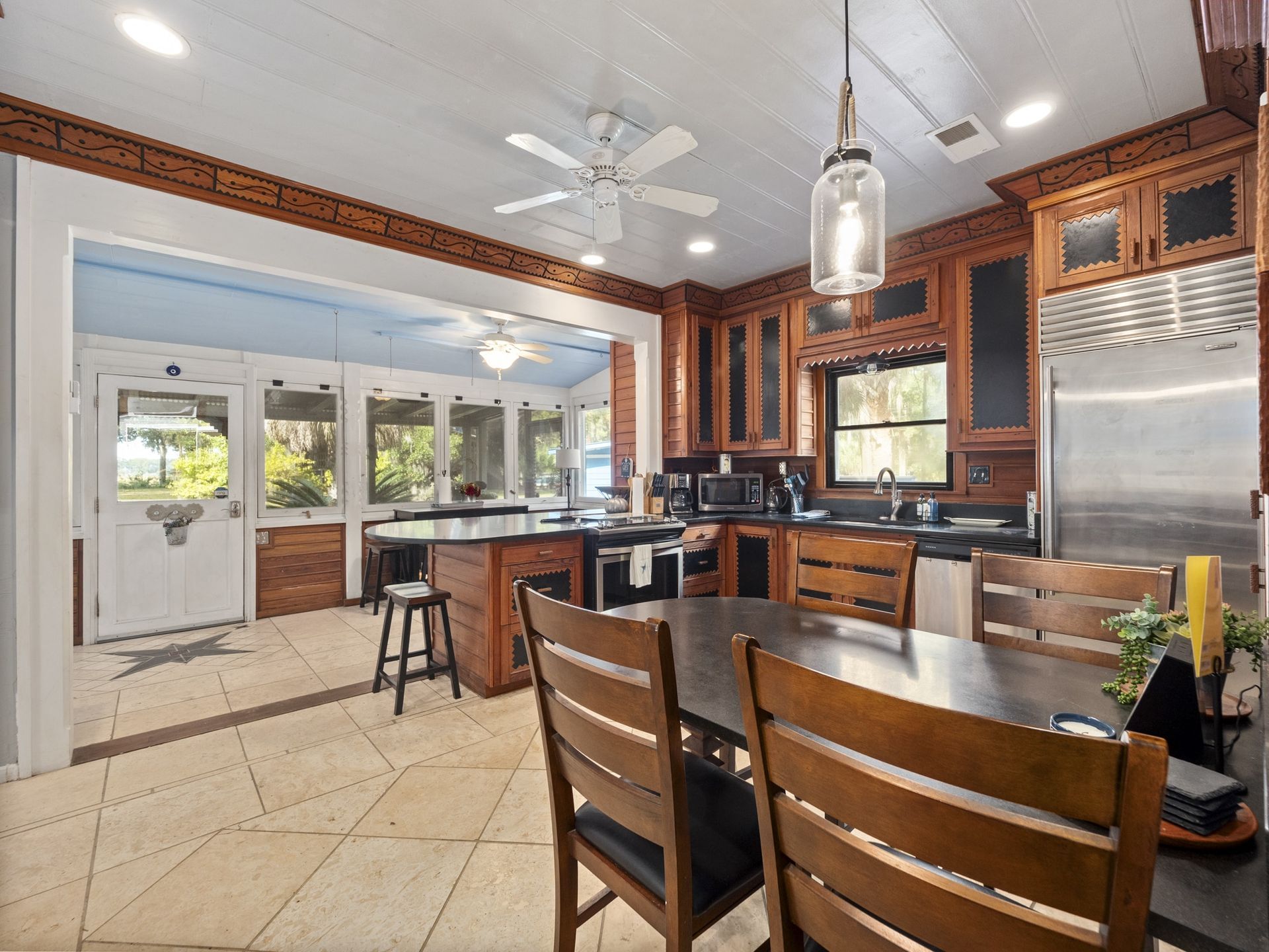 A kitchen with a table and chairs and a ceiling fan