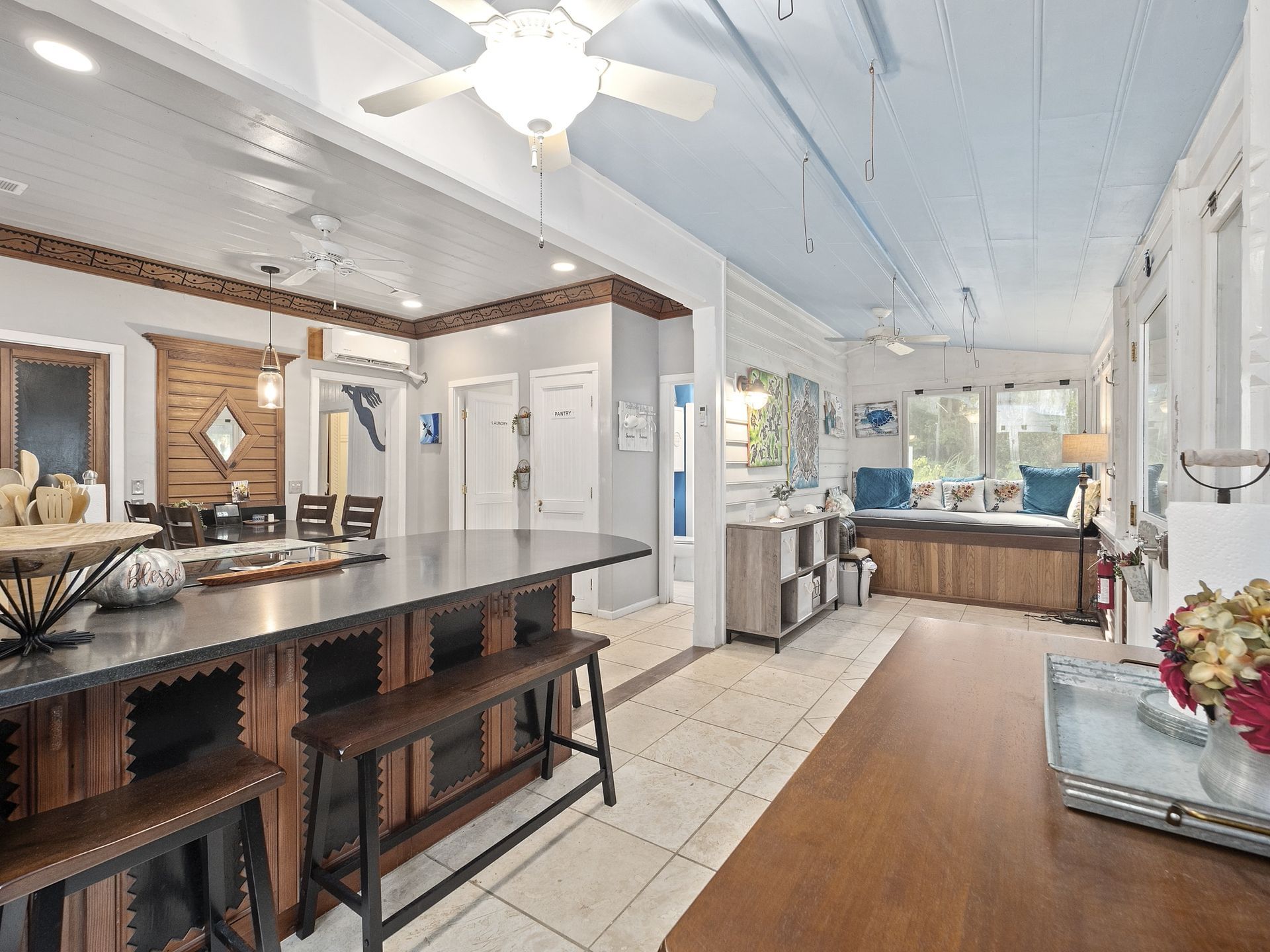 A kitchen with a large island and a ceiling fan.
