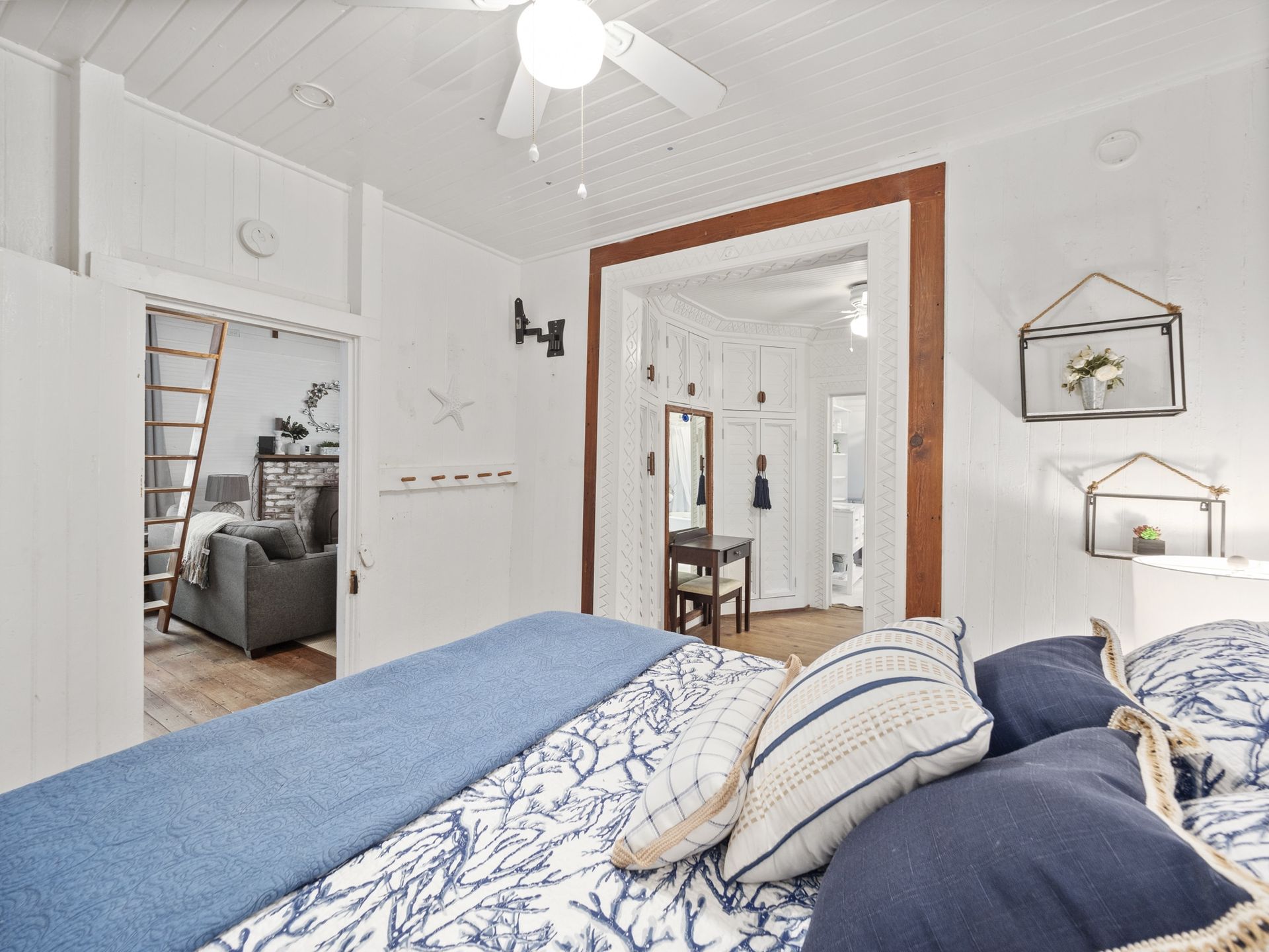A bedroom with a bed and a ceiling fan.