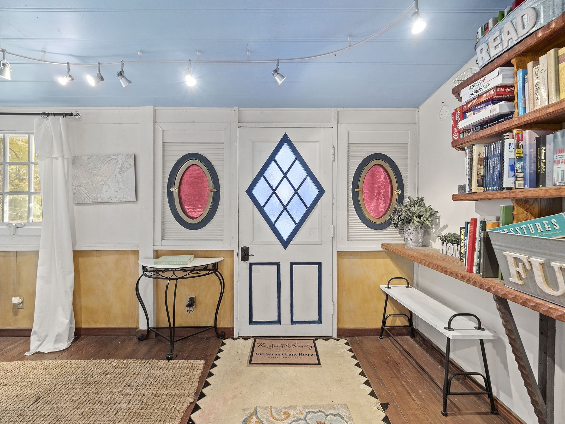 A living room with a blue ceiling and a white door.