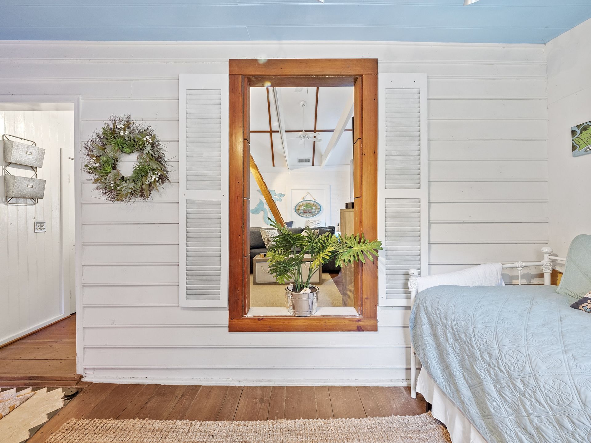 A bedroom with a bed and a window with shutters.
