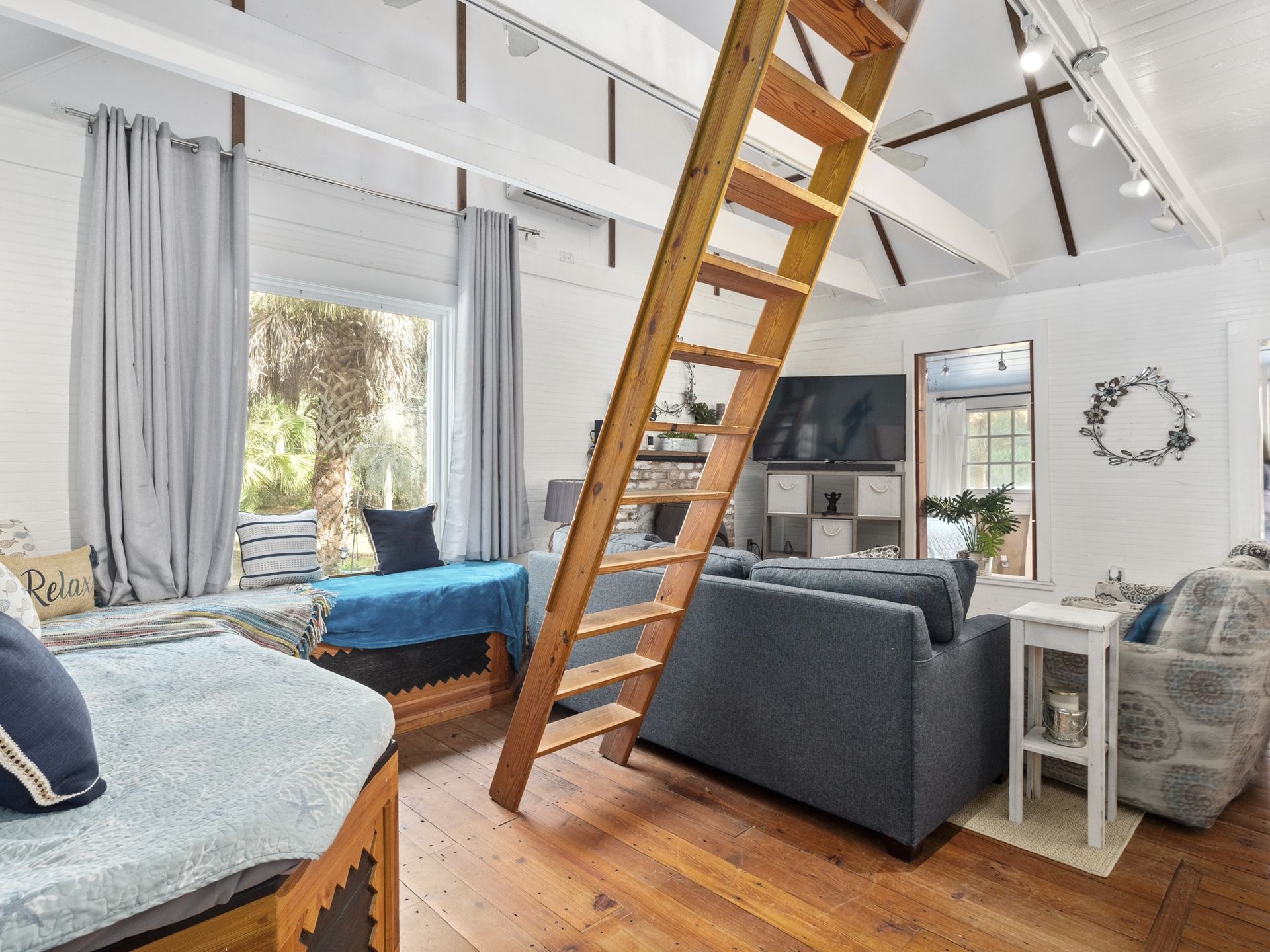 A living room with a wooden staircase leading to the second floor.