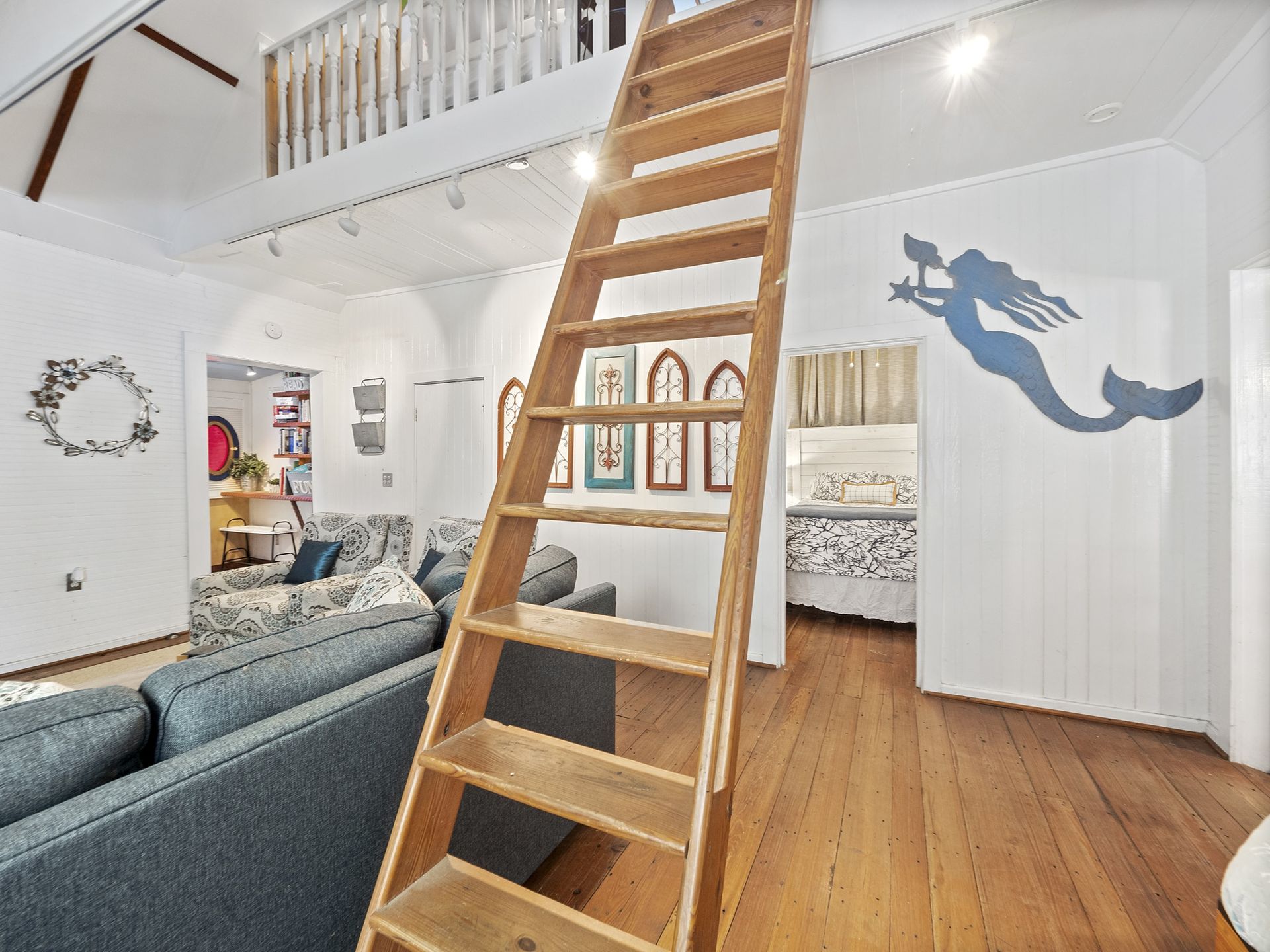 A wooden staircase leading up to a loft in a living room.