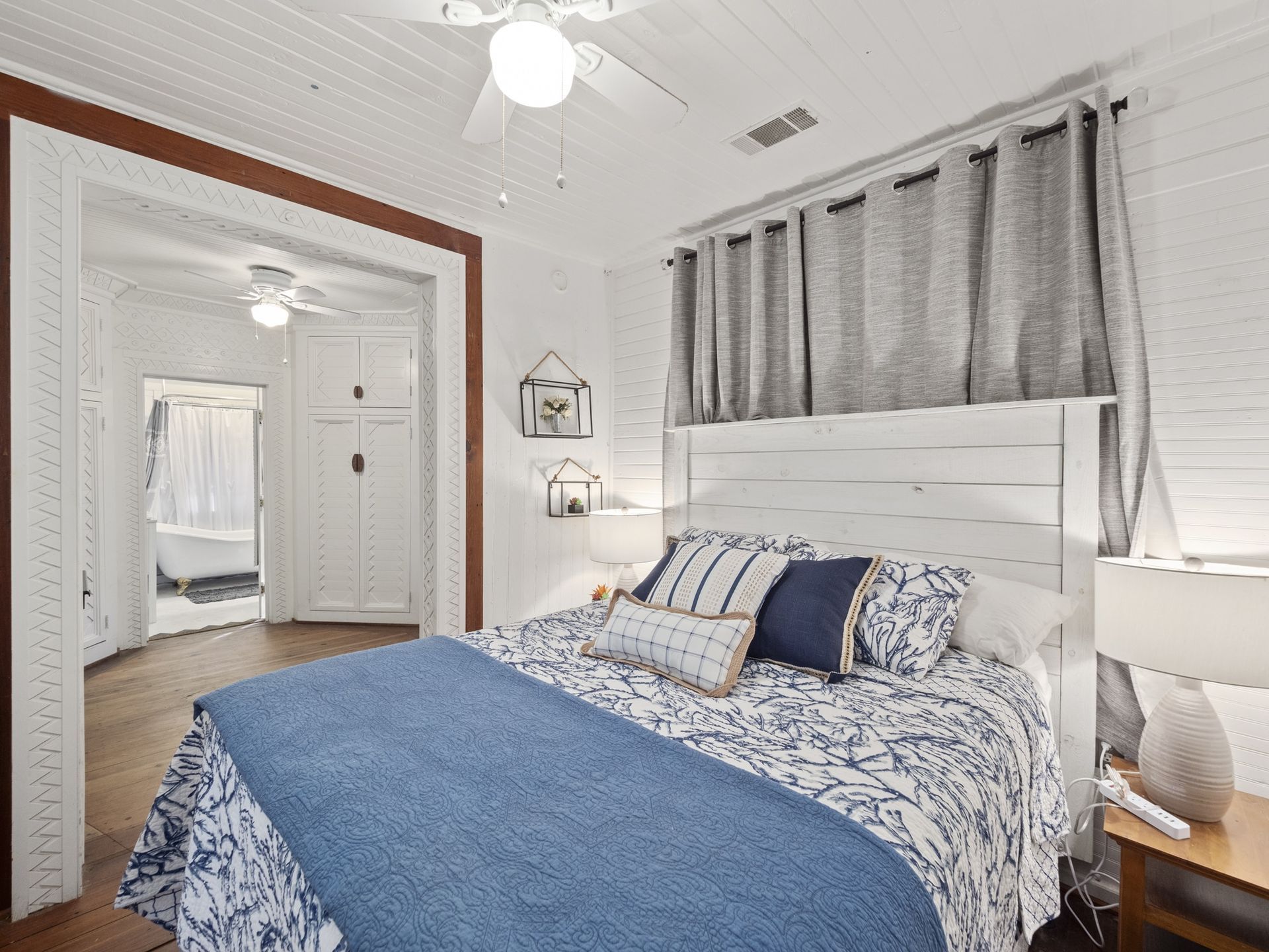 A bedroom with a large bed and a ceiling fan.