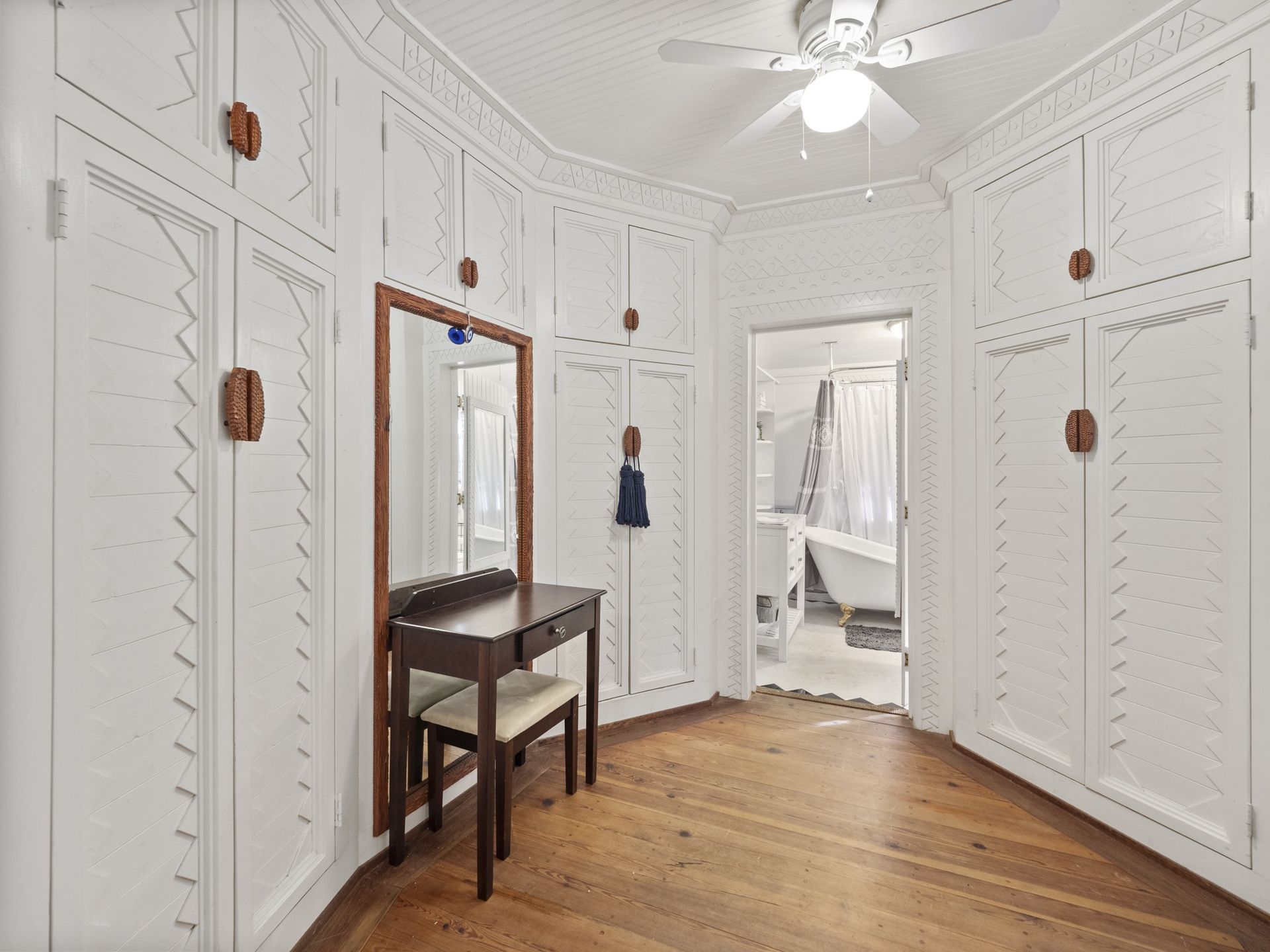 There is a ceiling fan in the room and a mirror on the wall.