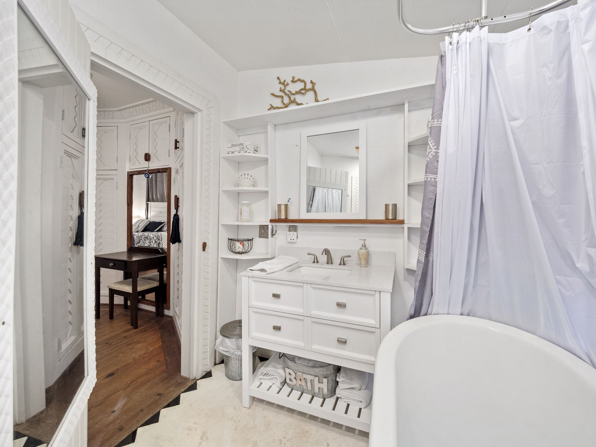 A bathroom with a tub , sink , mirror and shower curtain.