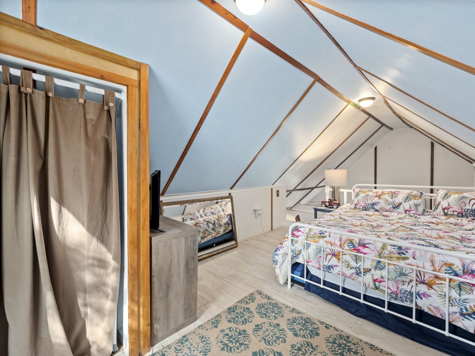 A bedroom with a king size bed in the attic.
