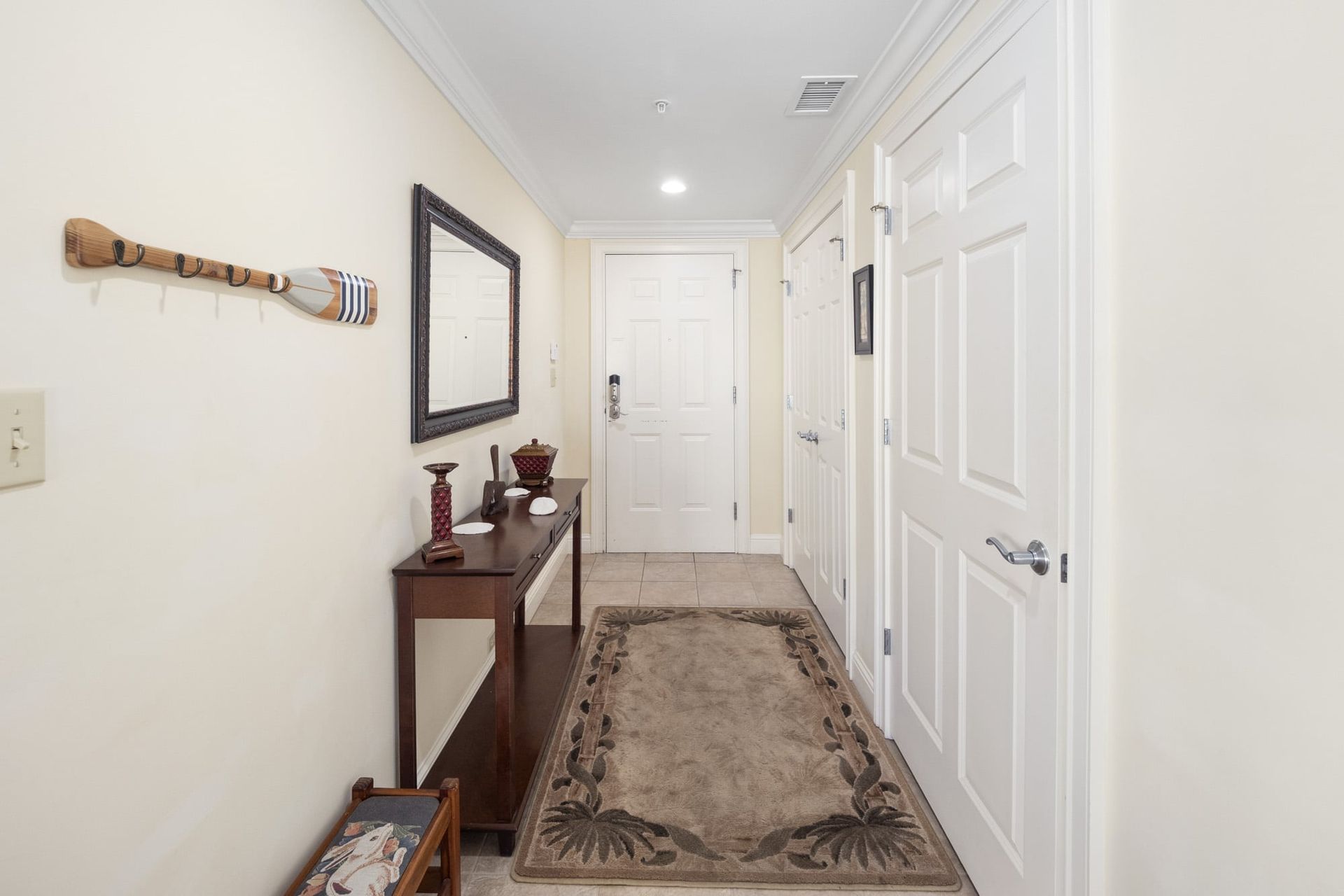 A hallway with a table and a mirror on the wall.