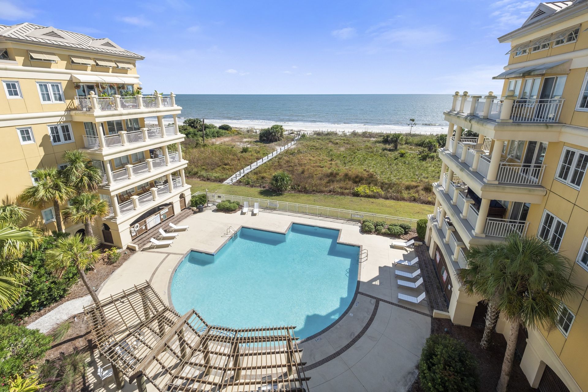 An aerial view of a large swimming pool surrounded by buildings next to the ocean.