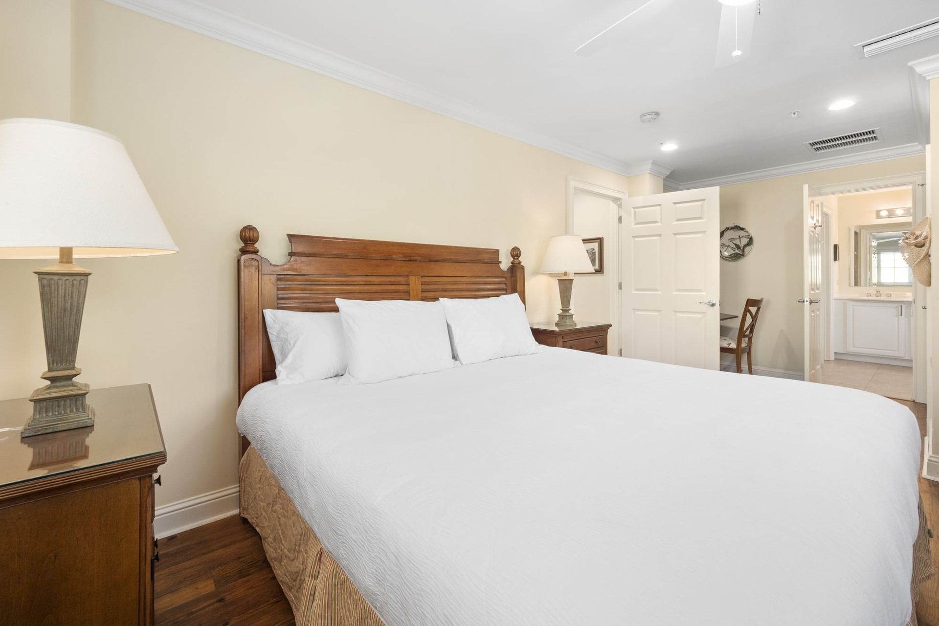 A bedroom with a king size bed , two lamps , and a nightstand.