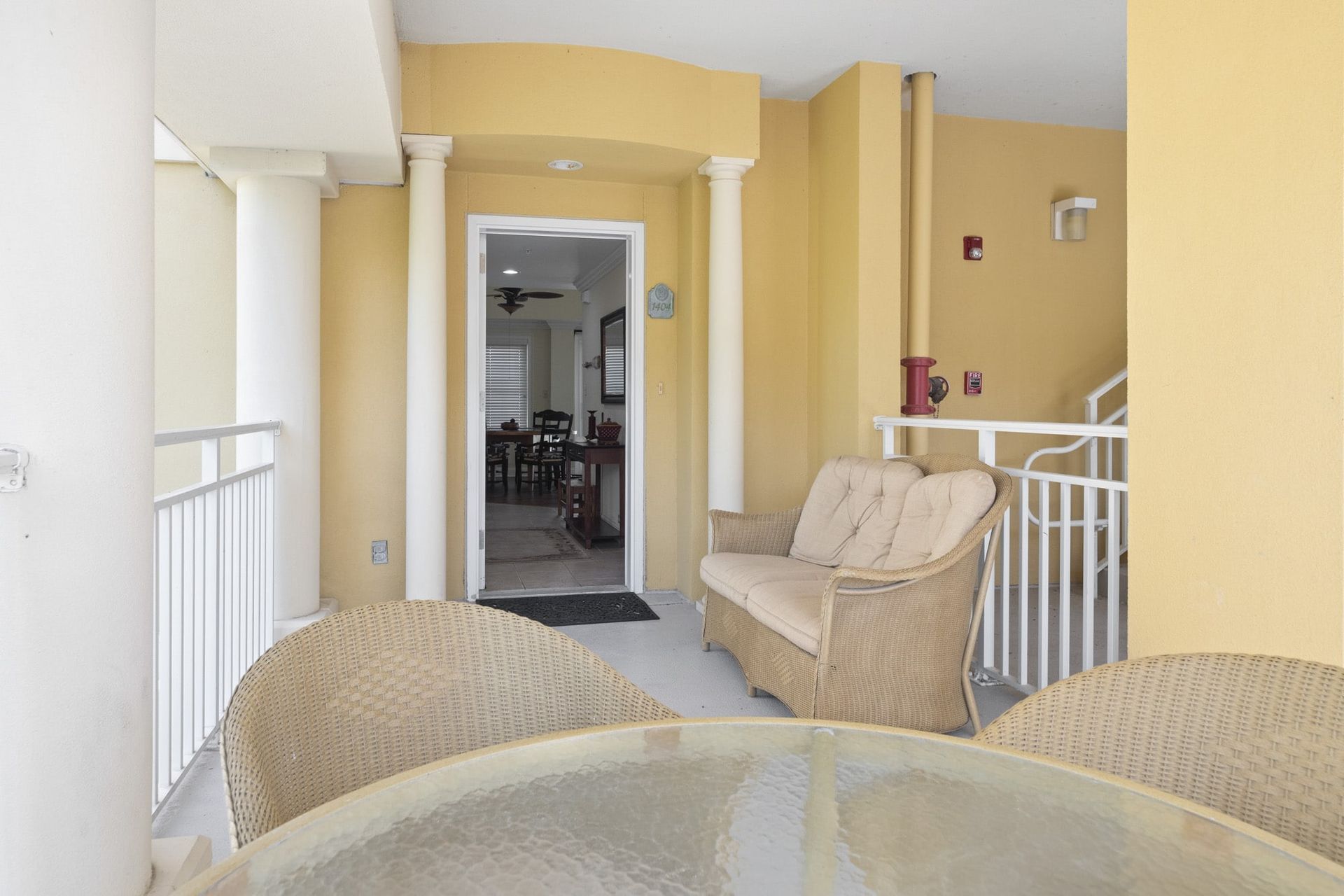 A balcony with a table , chairs and a couch.