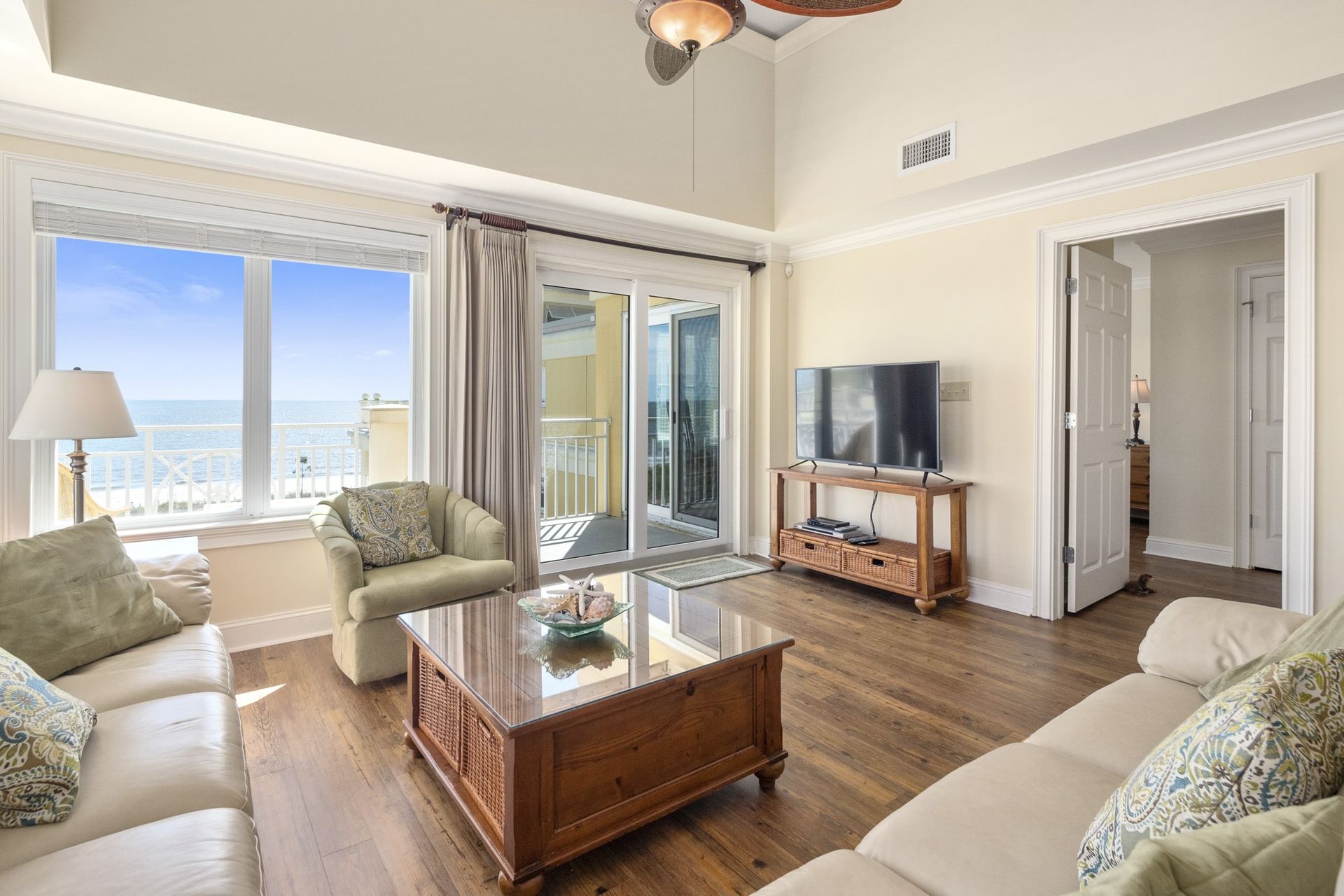 A living room with a couch , chair , coffee table and television.