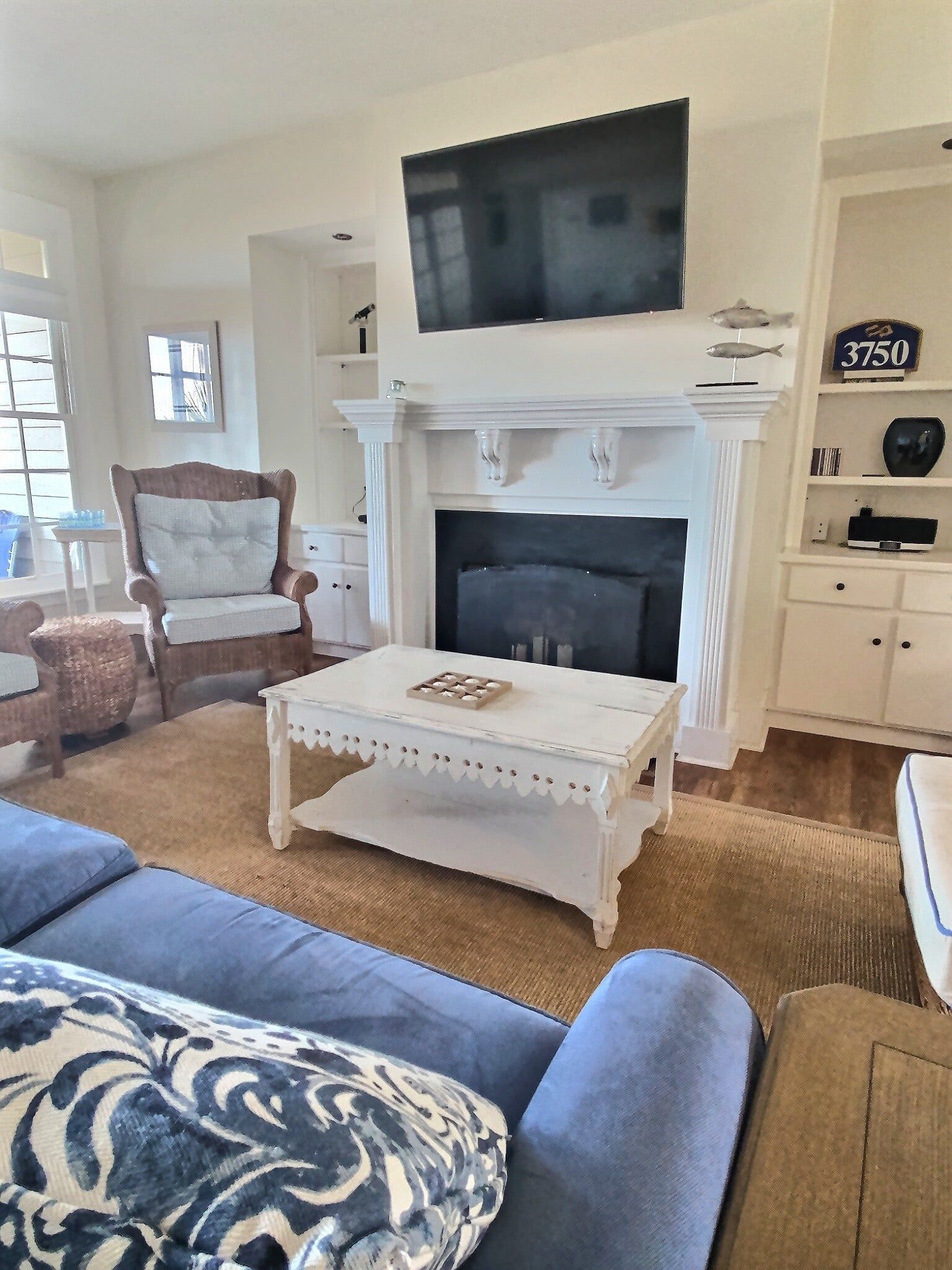 A living room with a fireplace , couch , chair and television.