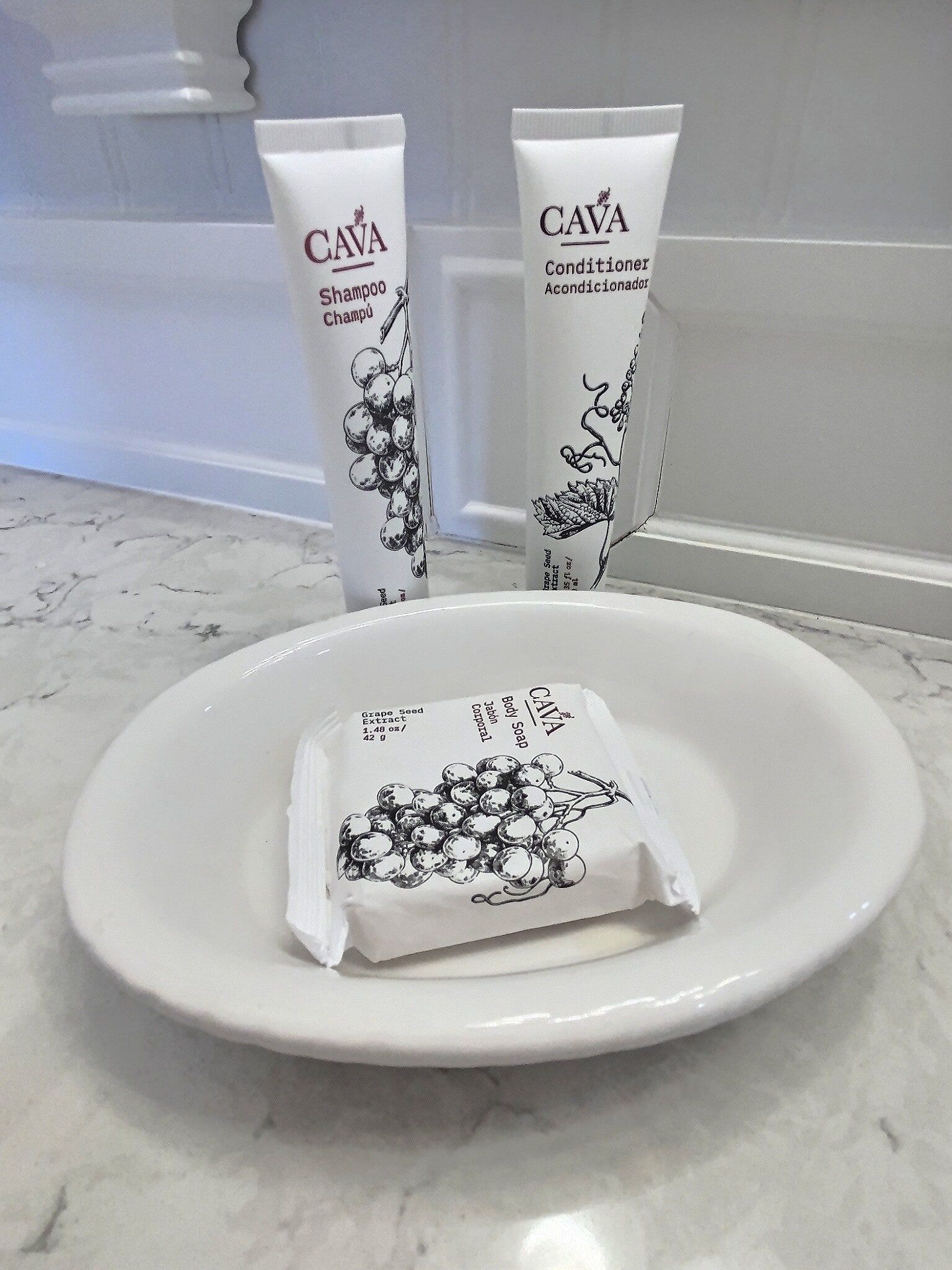 A white plate with a bar of soap and two tubes of lotion on it