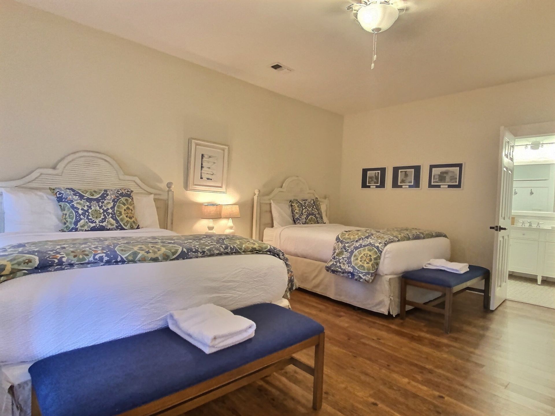 A bedroom with two beds and a bench