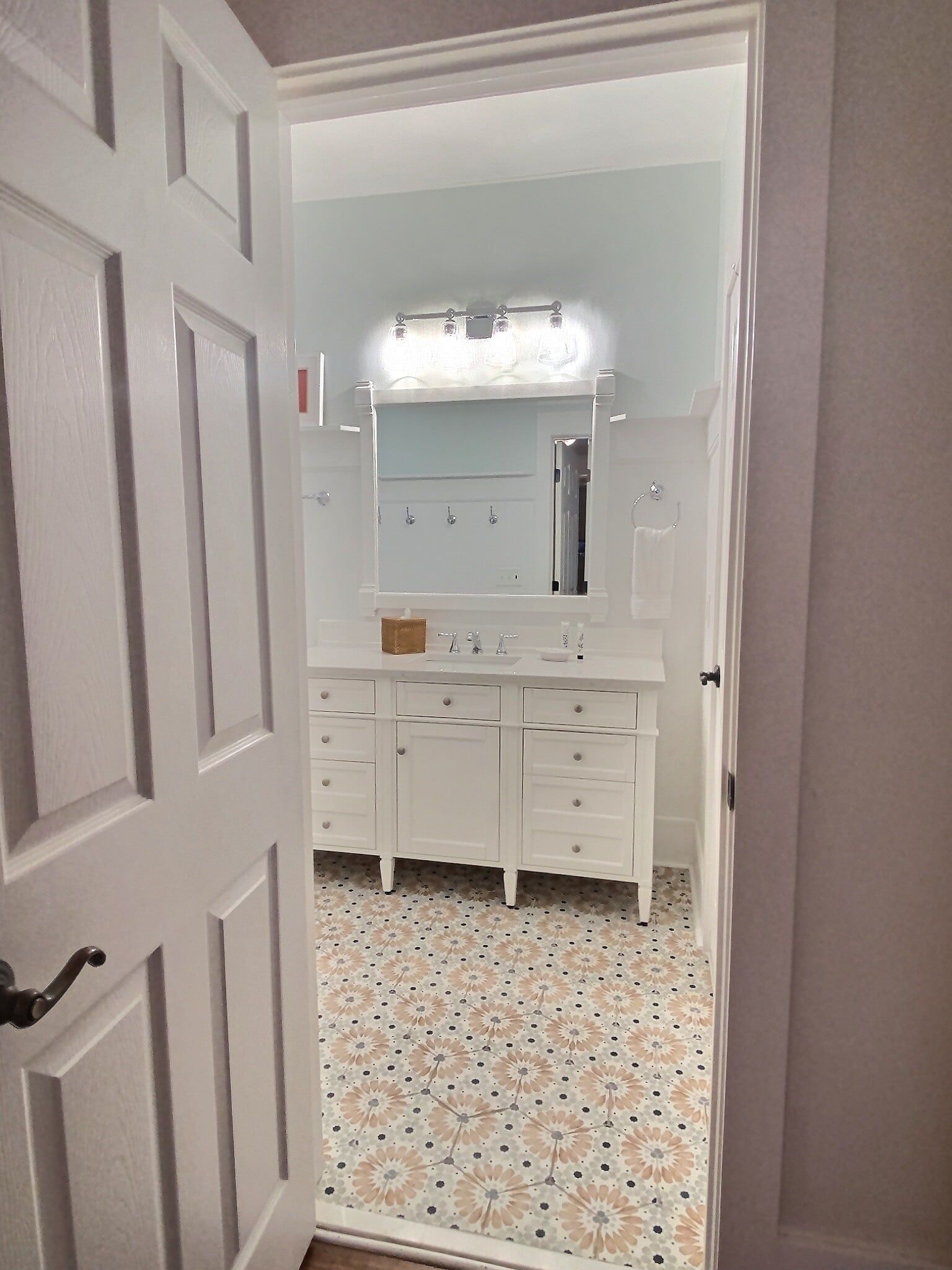 The door is open to a bathroom with a sink and mirror.