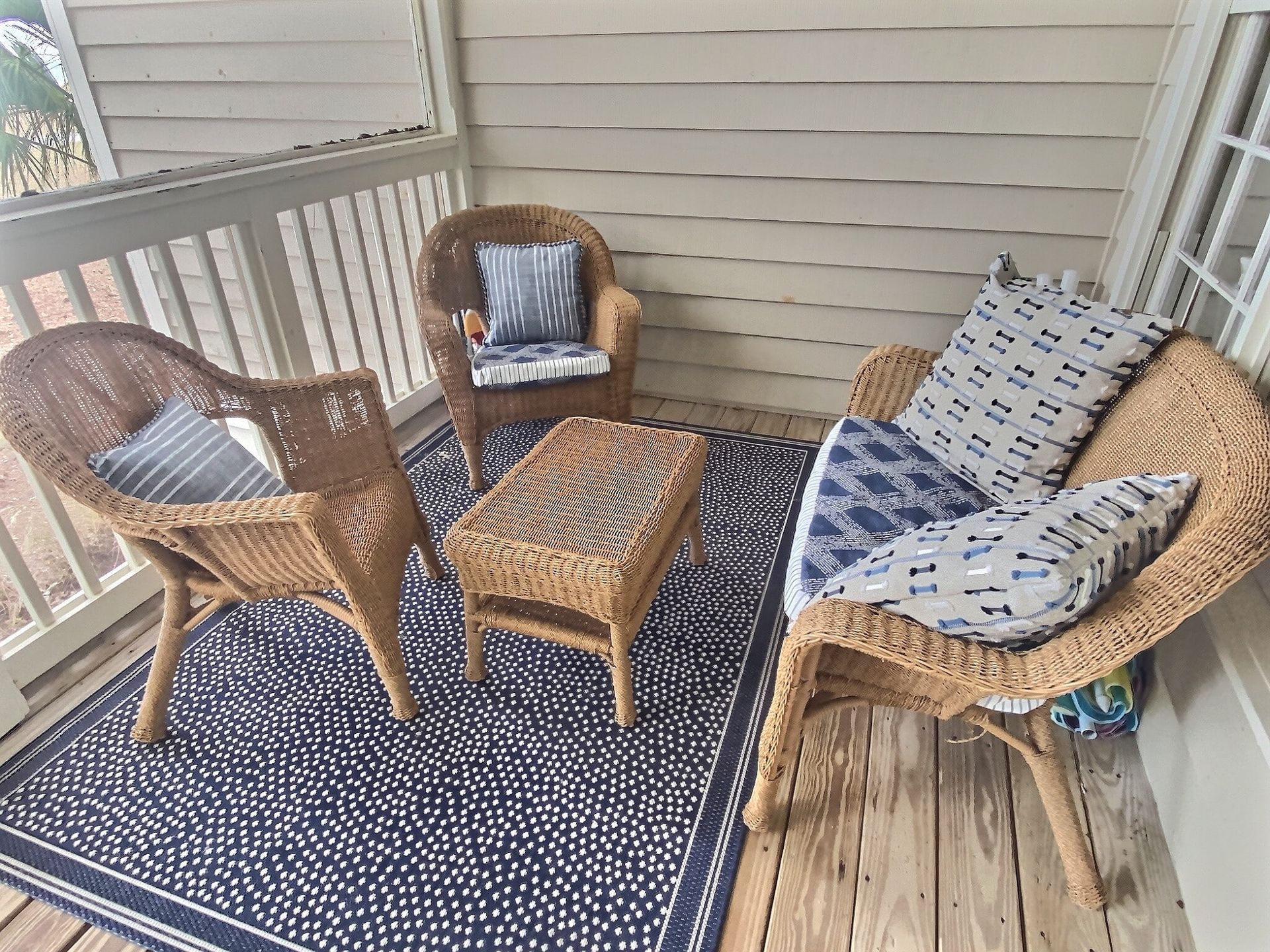There are two chairs and a table on the porch.