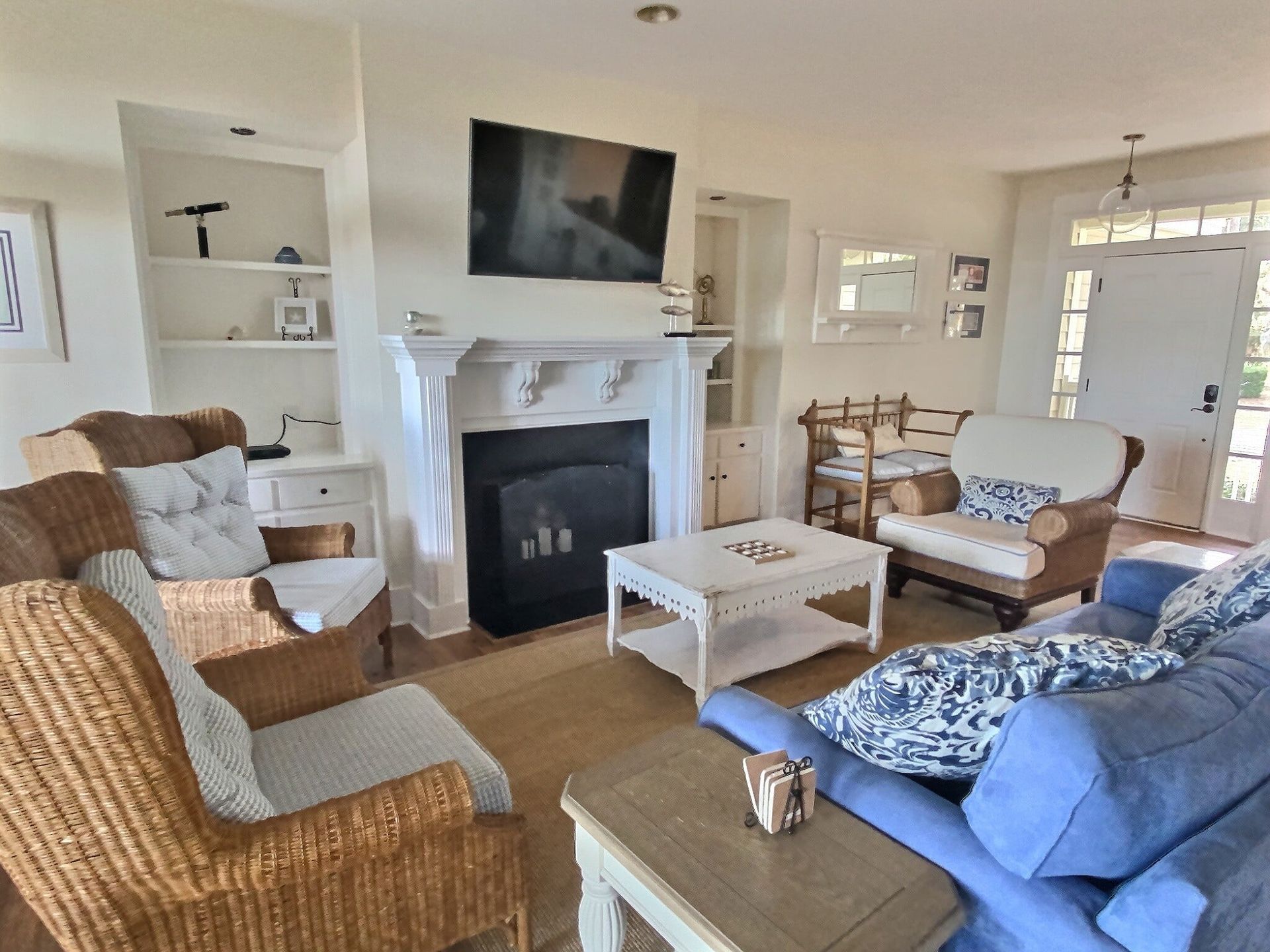 A living room with wicker furniture and a fireplace