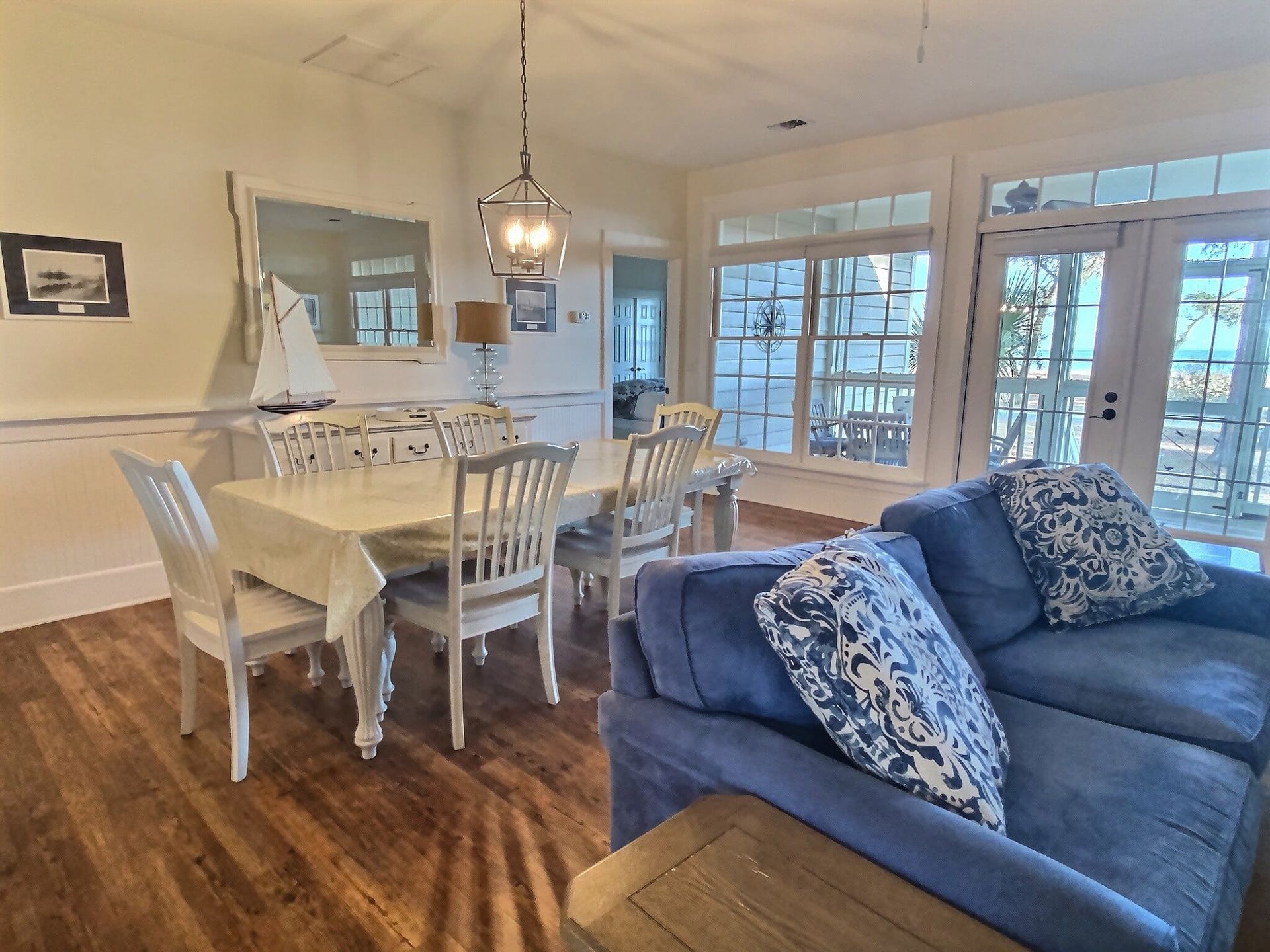 A living room with a blue couch , table and chairs