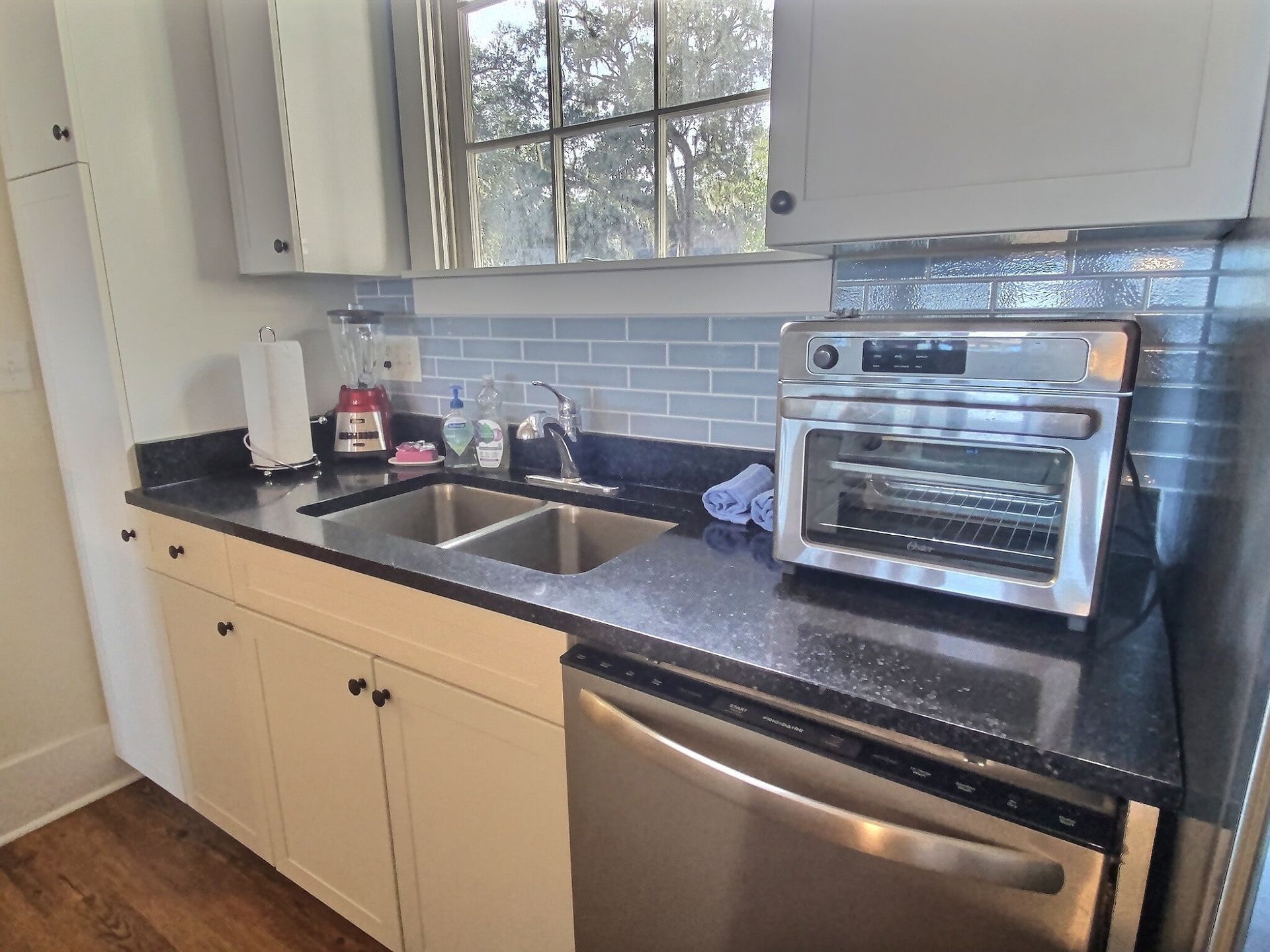 A kitchen with a sink , dishwasher , oven and microwave.