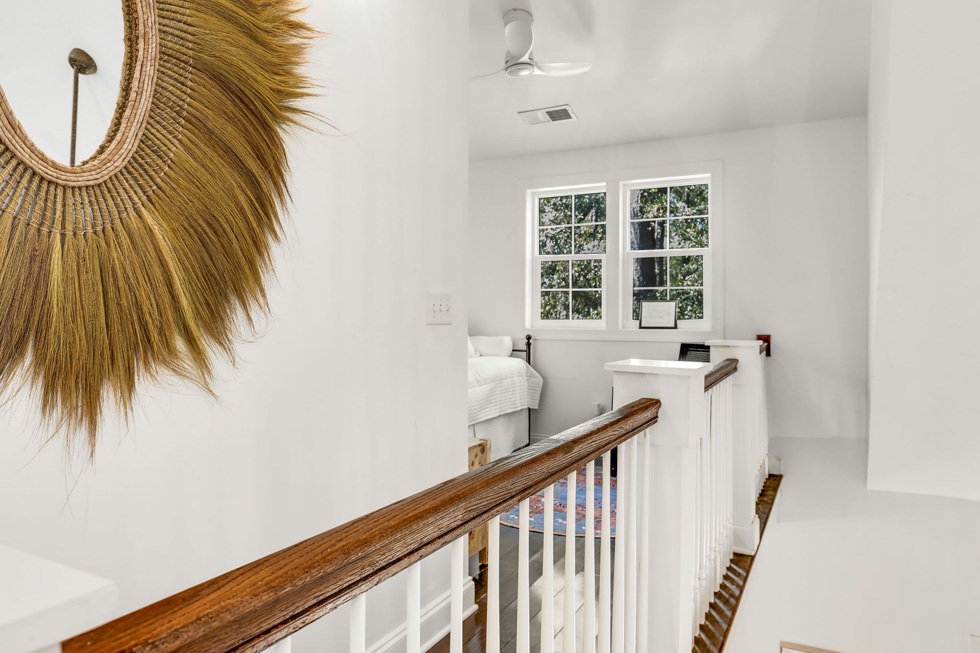 A staircase with a wooden railing and a mirror on the wall.