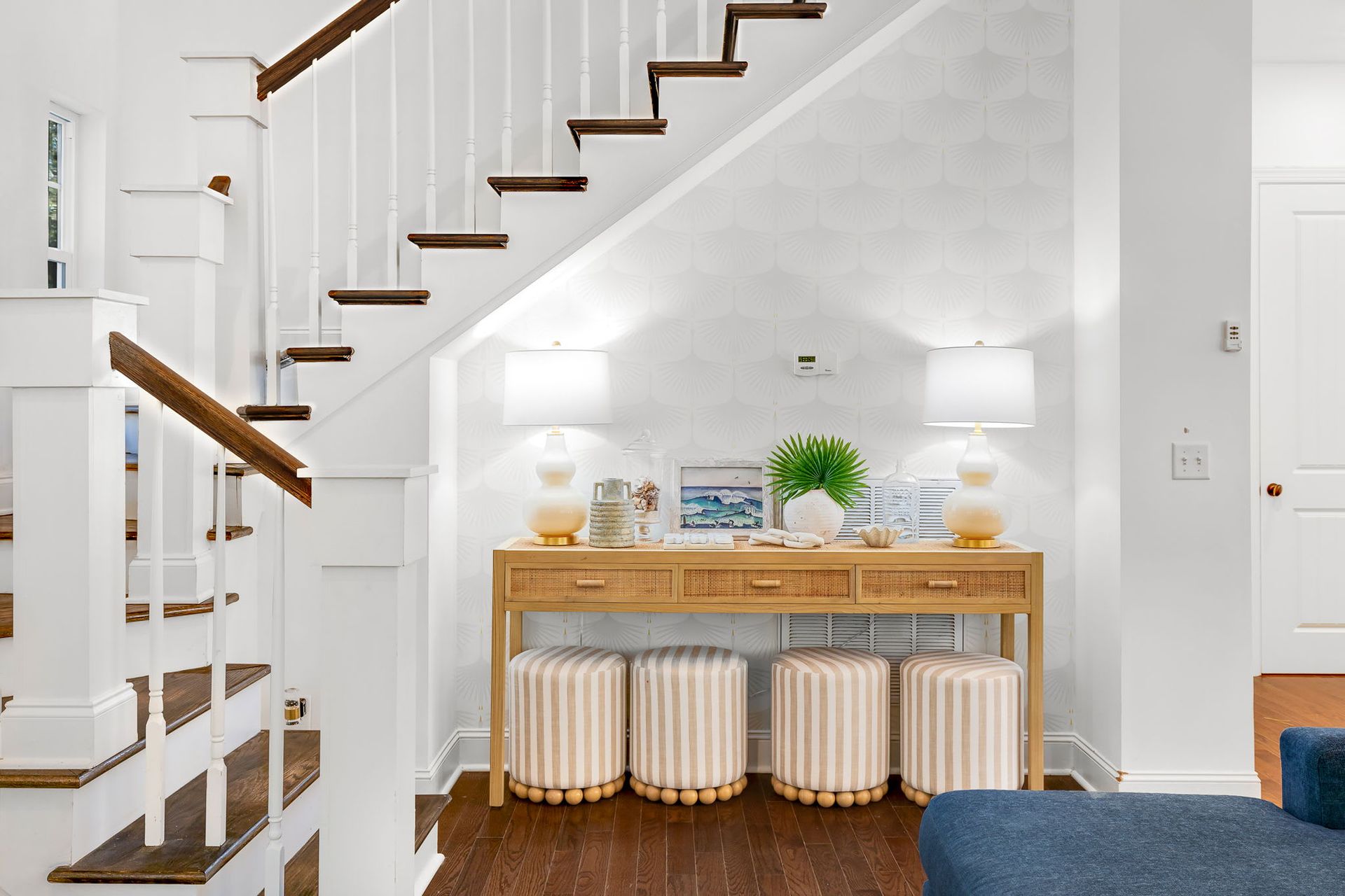 There is a table under the stairs in the living room.