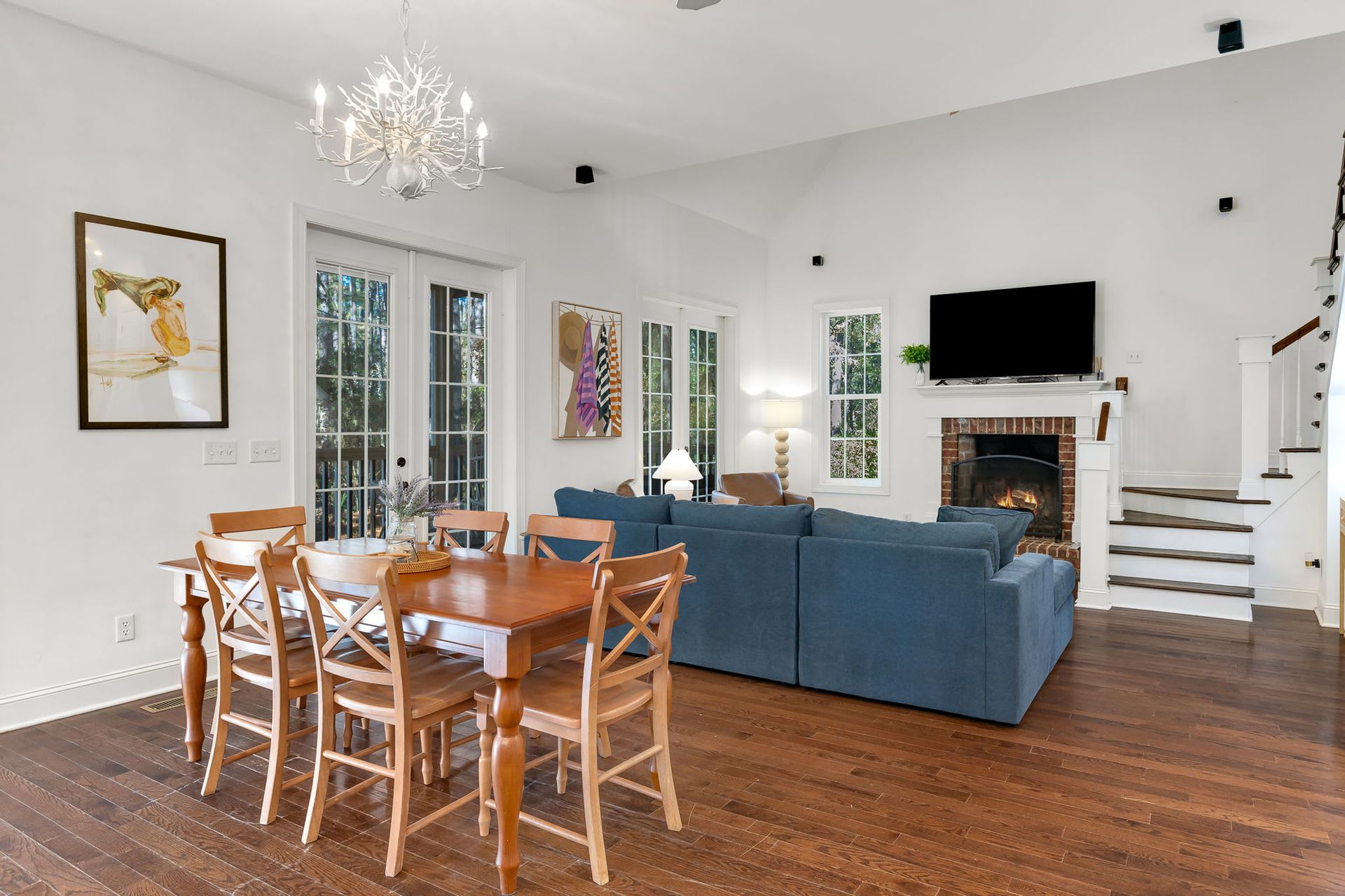A living room with a blue couch , table and chairs.