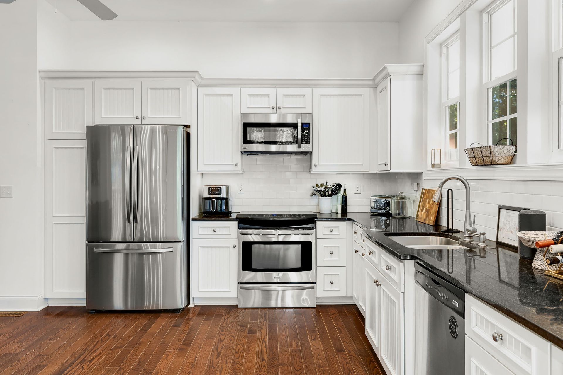 A kitchen with stainless steel appliances and white cabinets.