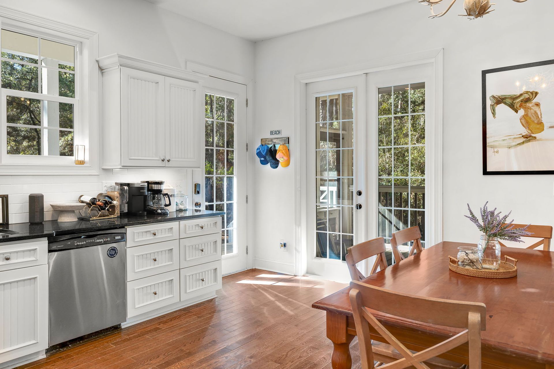 A kitchen with stainless steel appliances and a wooden table and chairs.