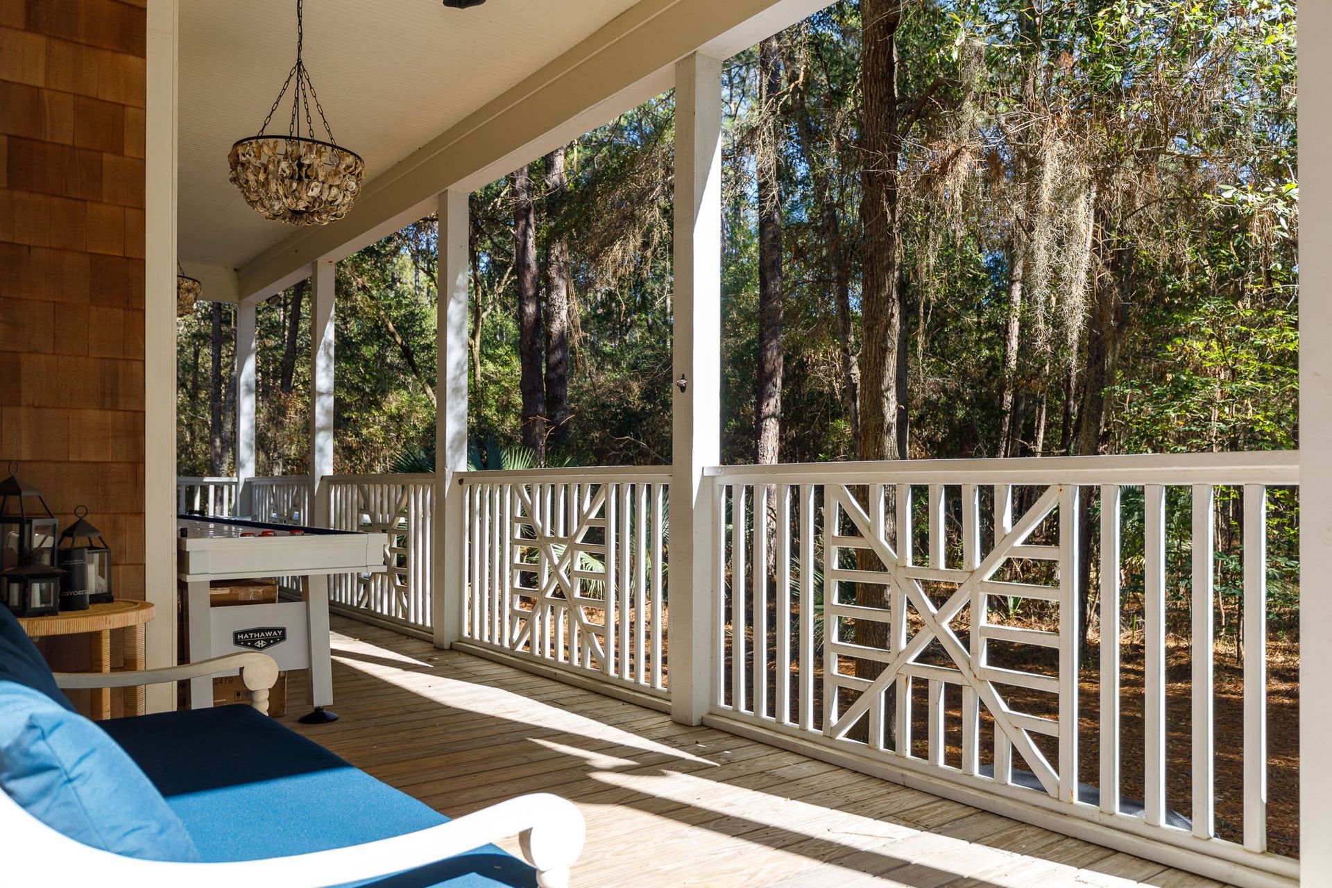 A porch with a blue couch and a white railing