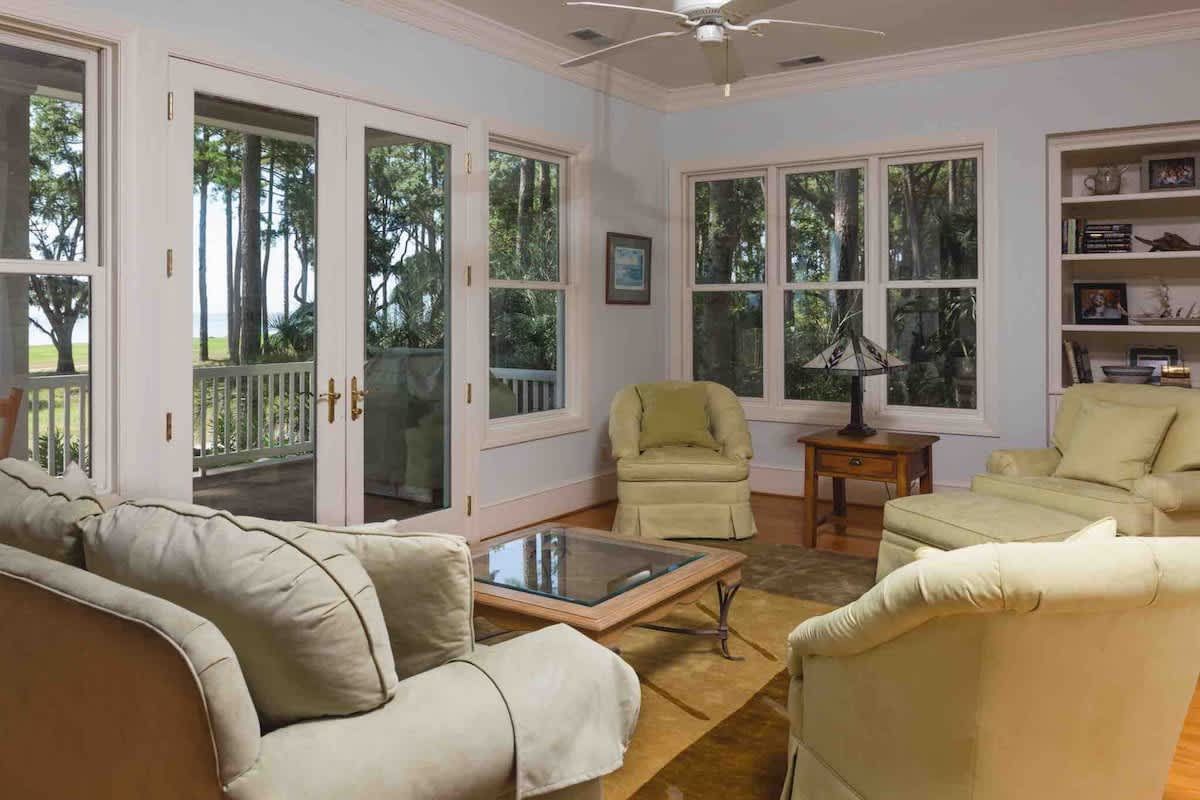 A porch with a blue couch and a white railing