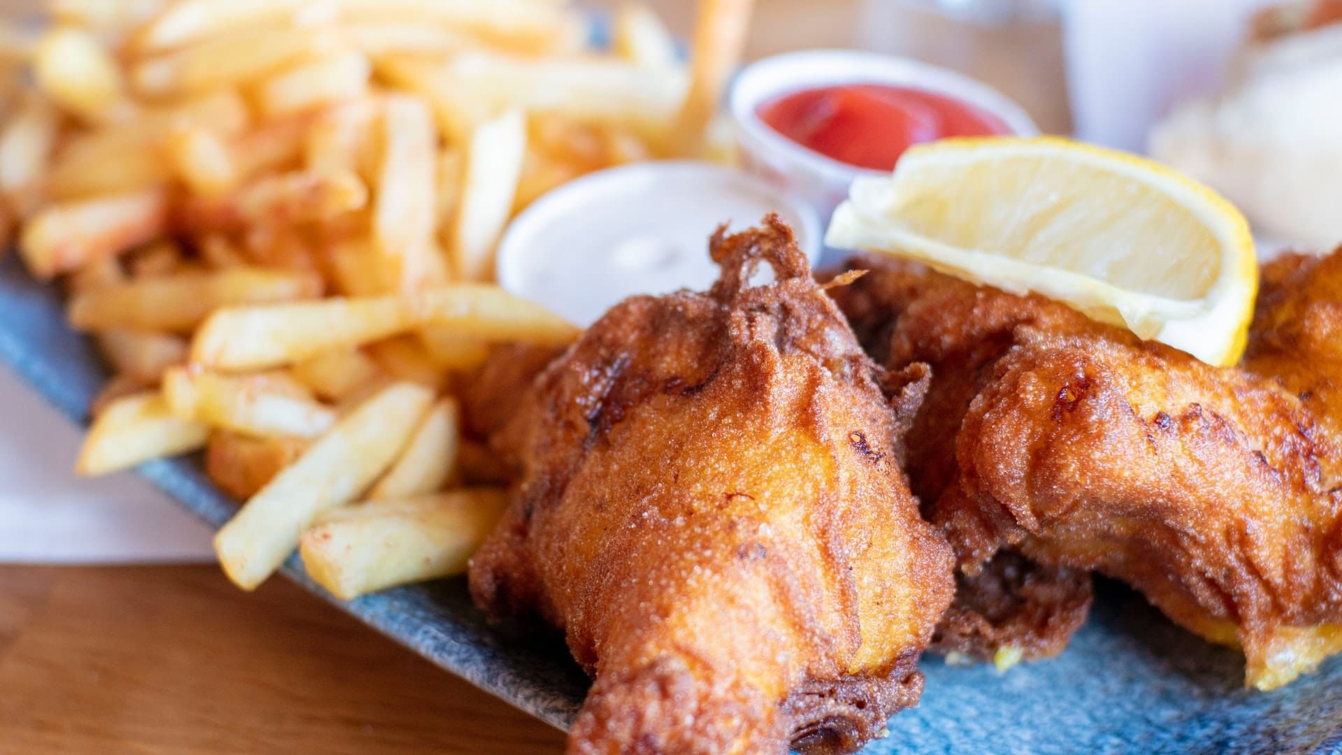 A plate of fried chicken and french fries on a table.