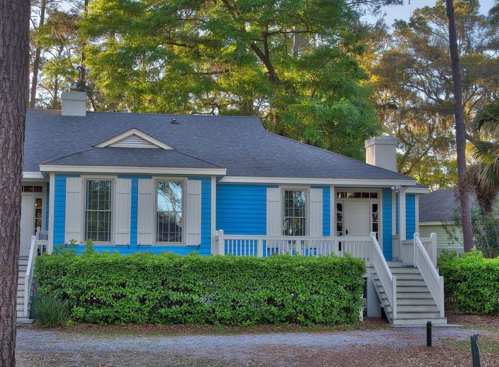 A blue and white house with a porch and stairs