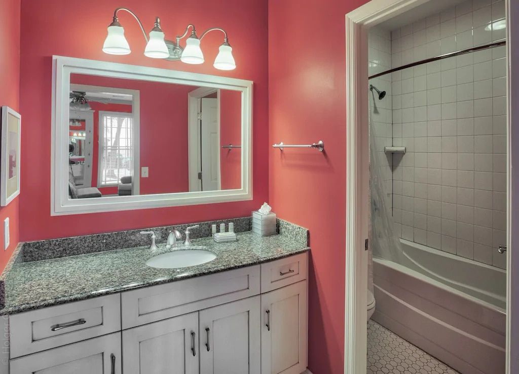 A bathroom with pink walls and a large mirror