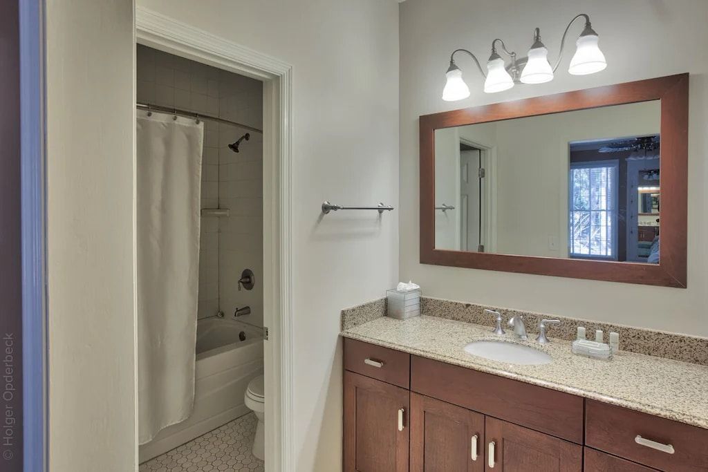 A bathroom with a large mirror and a sink